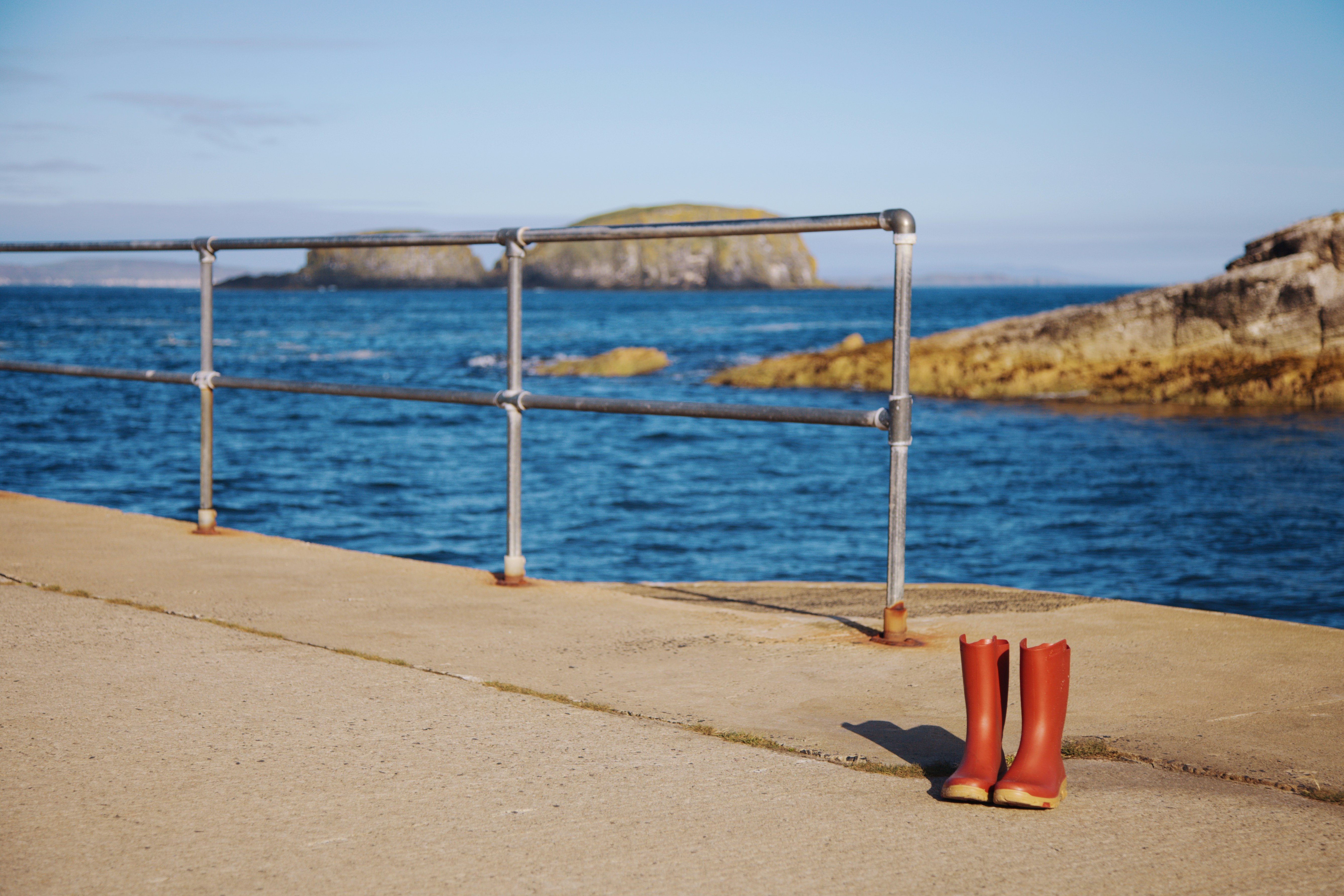 A pair of red boots sitting on the side of a road