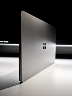 A laptop computer sitting on top of a white table