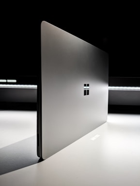 A laptop computer sitting on top of a white table