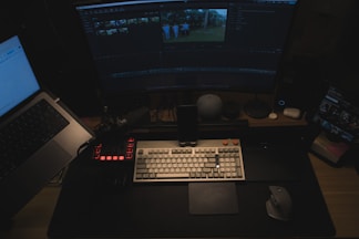 A computer desk with two laptops and a monitor