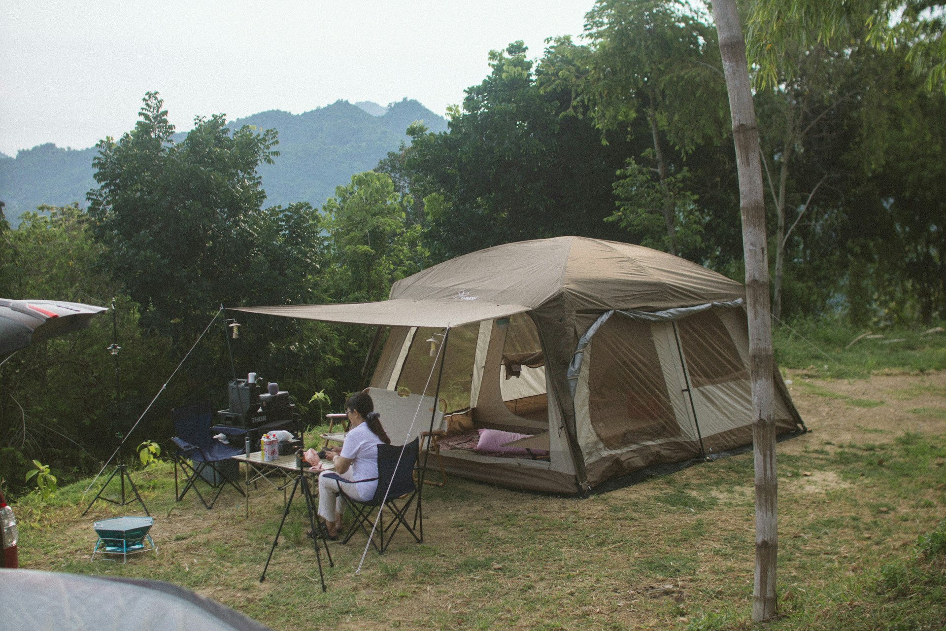 A group of people sitting outside of a tent
