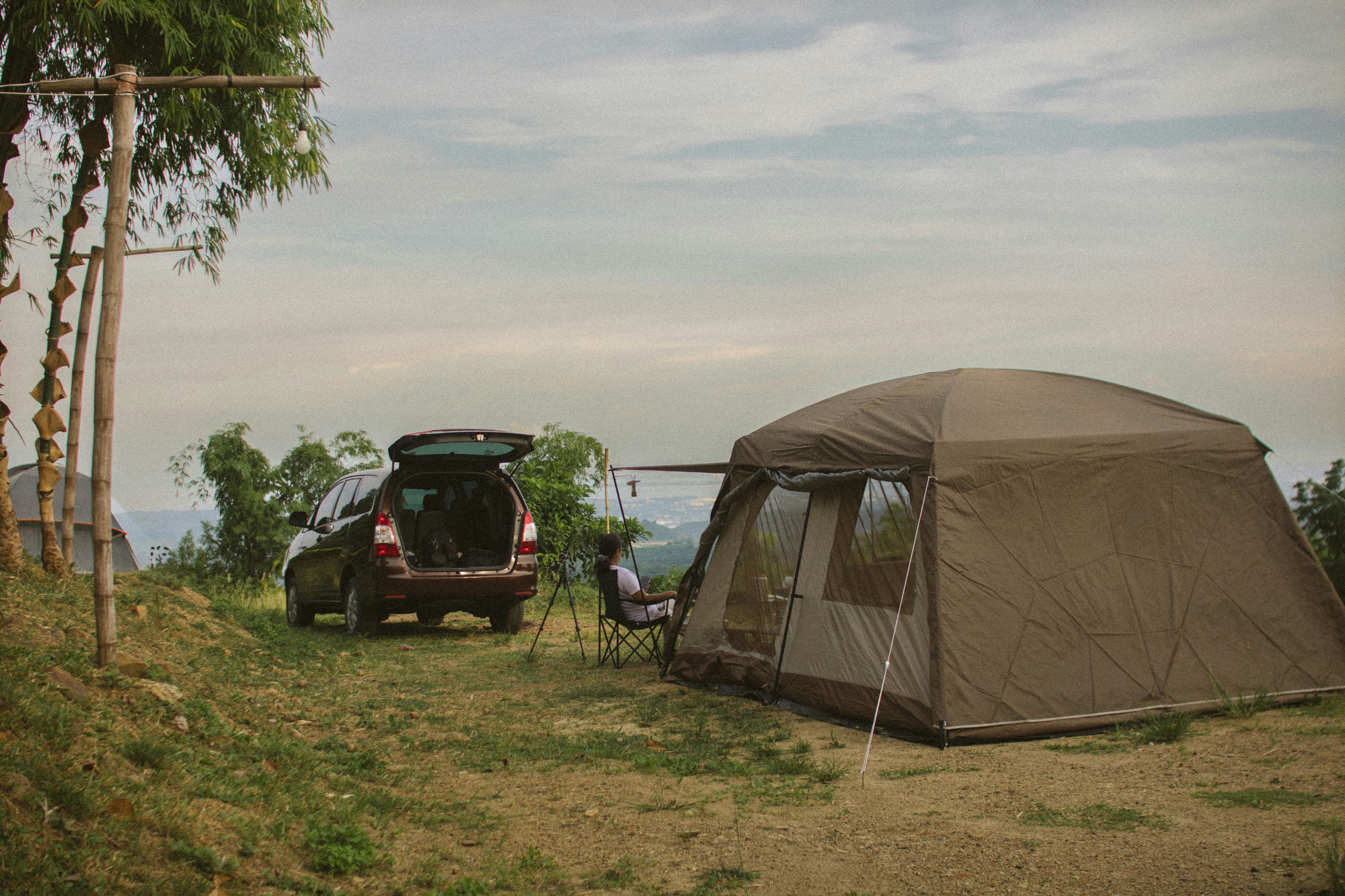 Un'auto parcheggiata accanto a una tenda in un campo