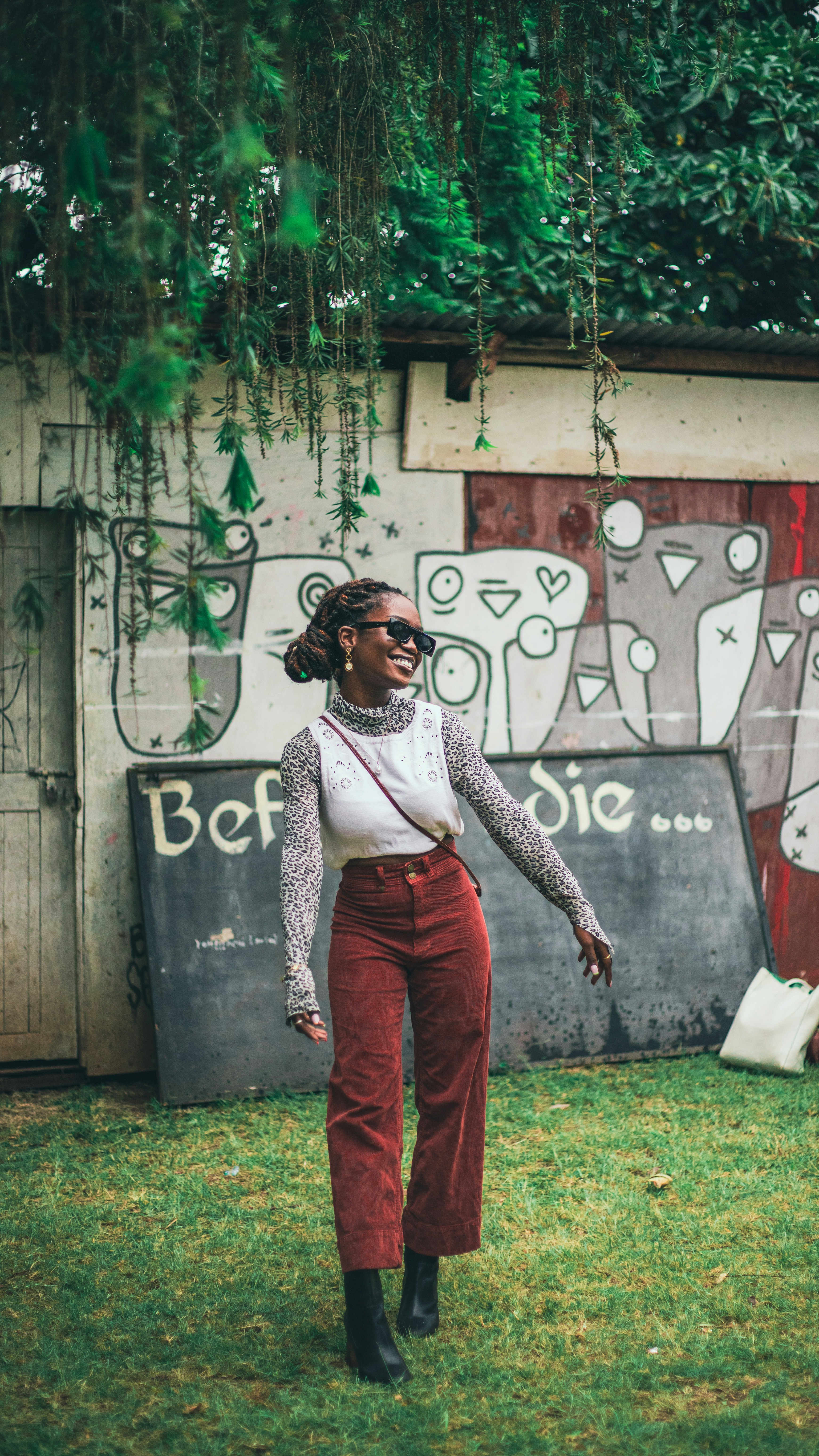 A woman standing in front of a wall with graffiti on it