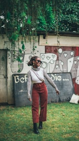 A woman standing in front of a wall with graffiti on it