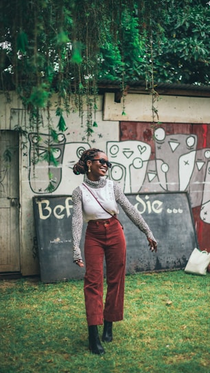 A woman standing in front of a wall with graffiti on it