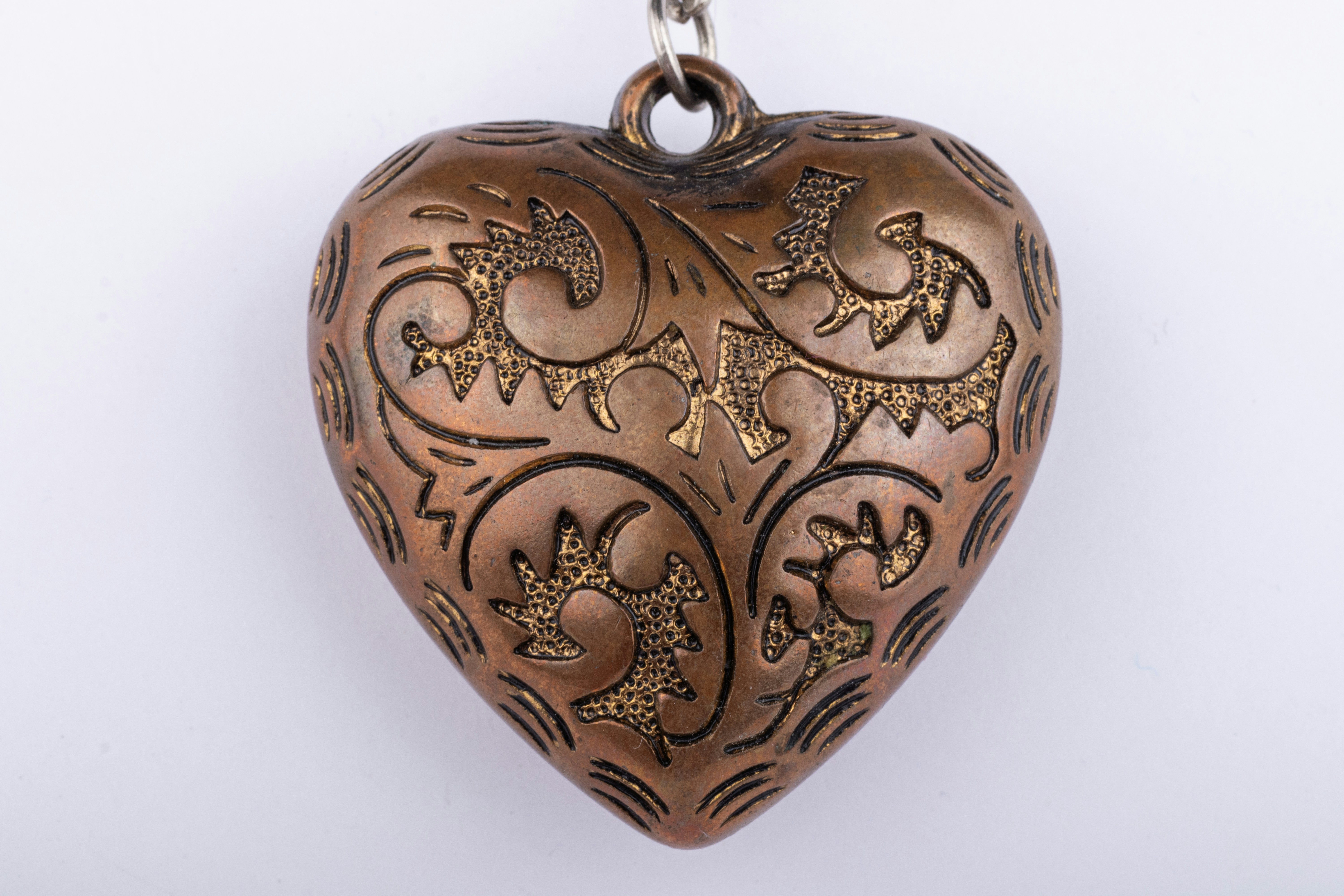A heart shaped locke with a chain hanging from it