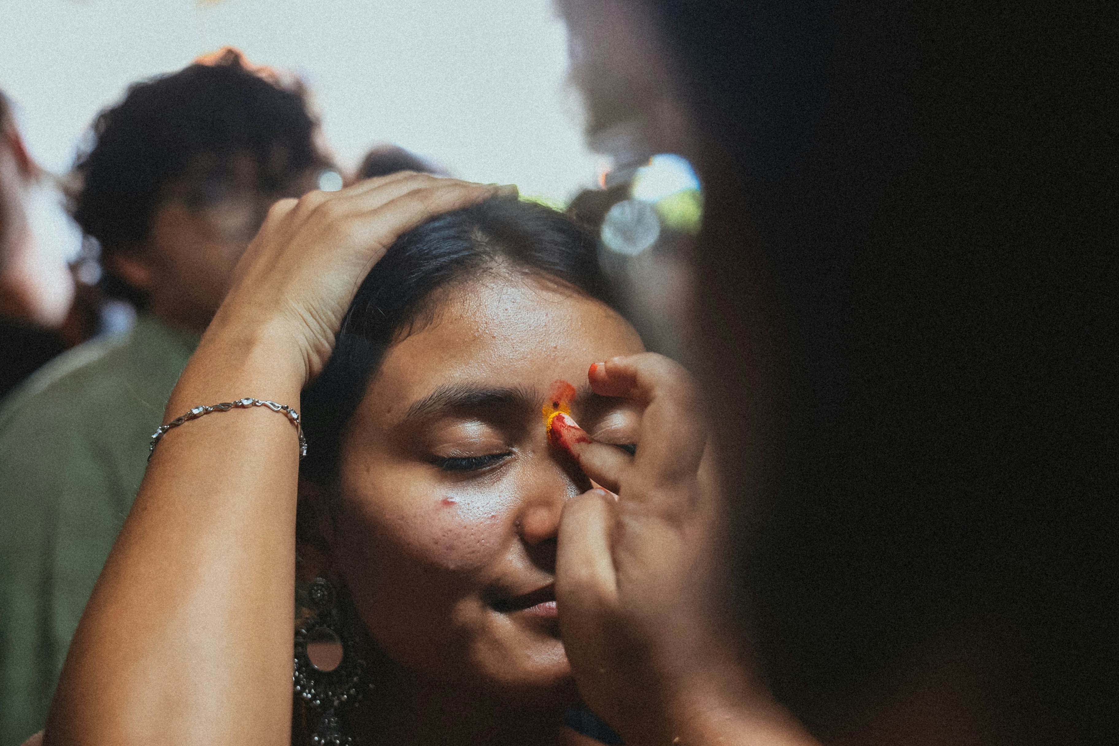 Woman applying flower to forehead