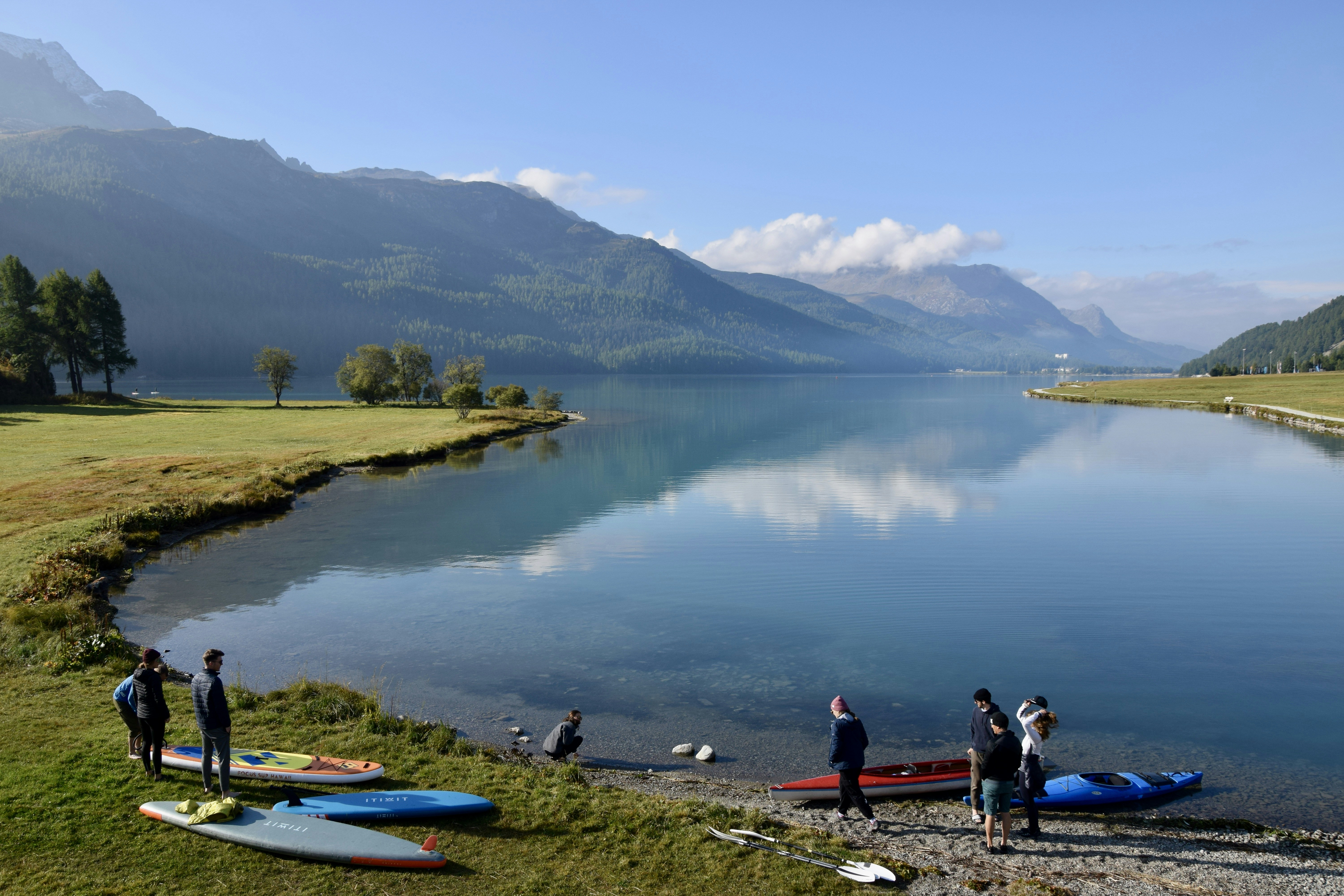 A group of people standing next to a body of water