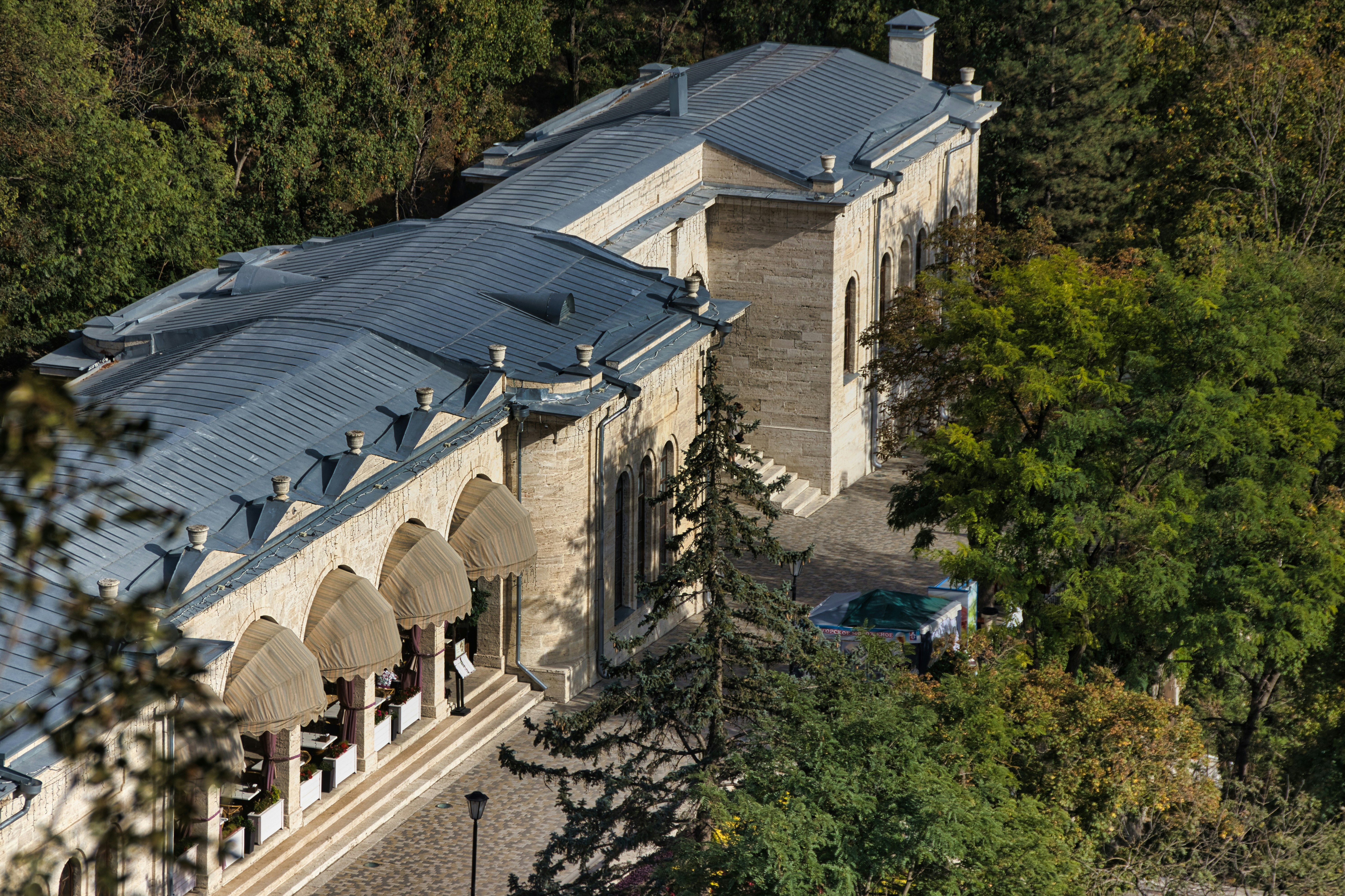 An aerial view of a large white house surrounded by trees