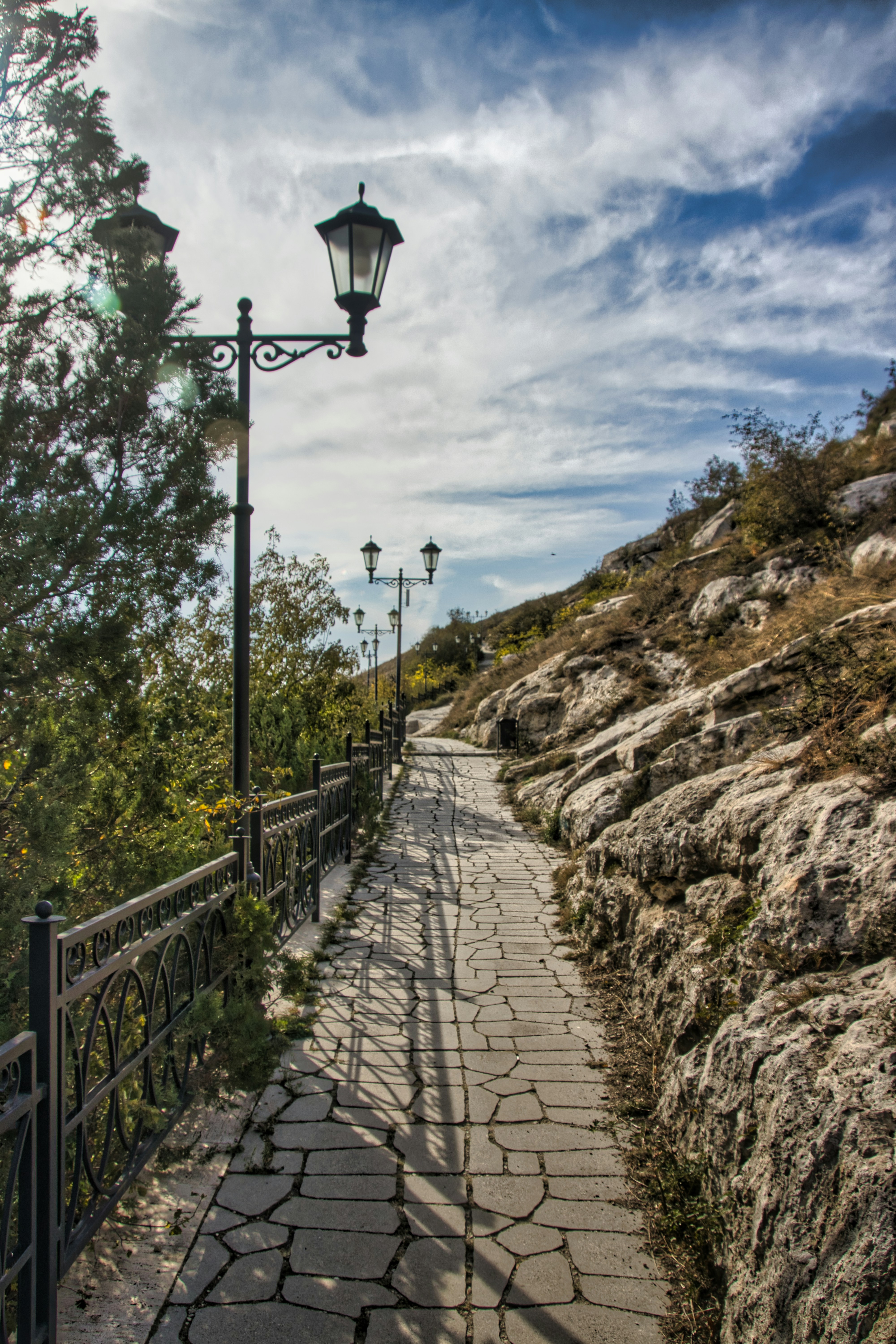 A stone path with a lamp post on top of it