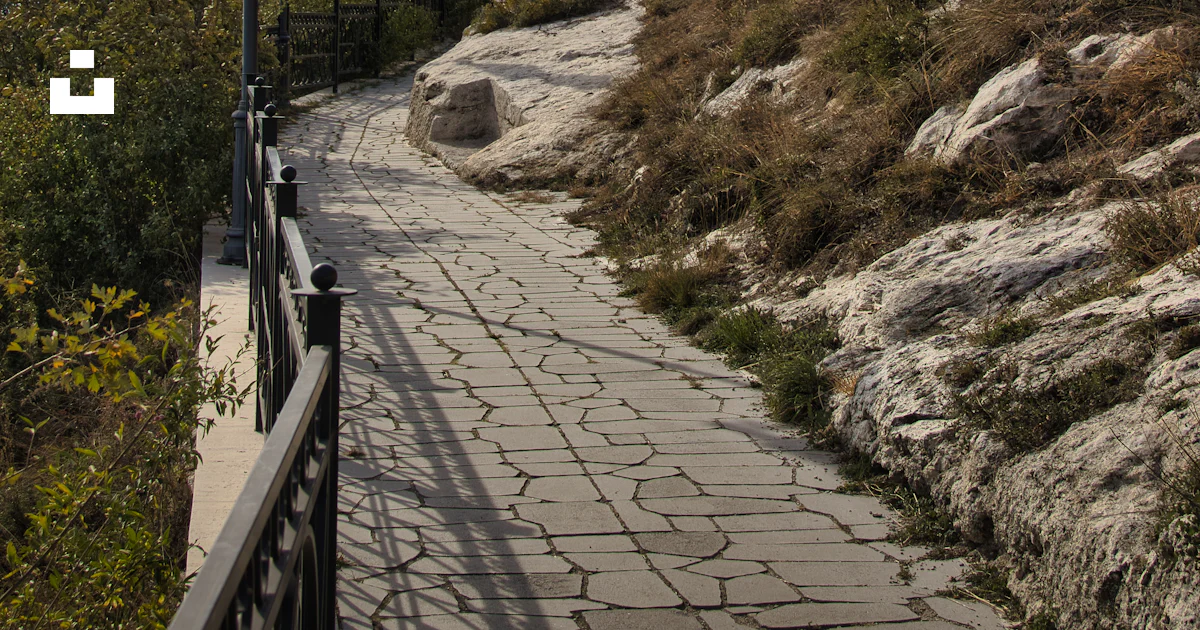 A stone path leading up a hill to a light pole photo – Free Path Image ...