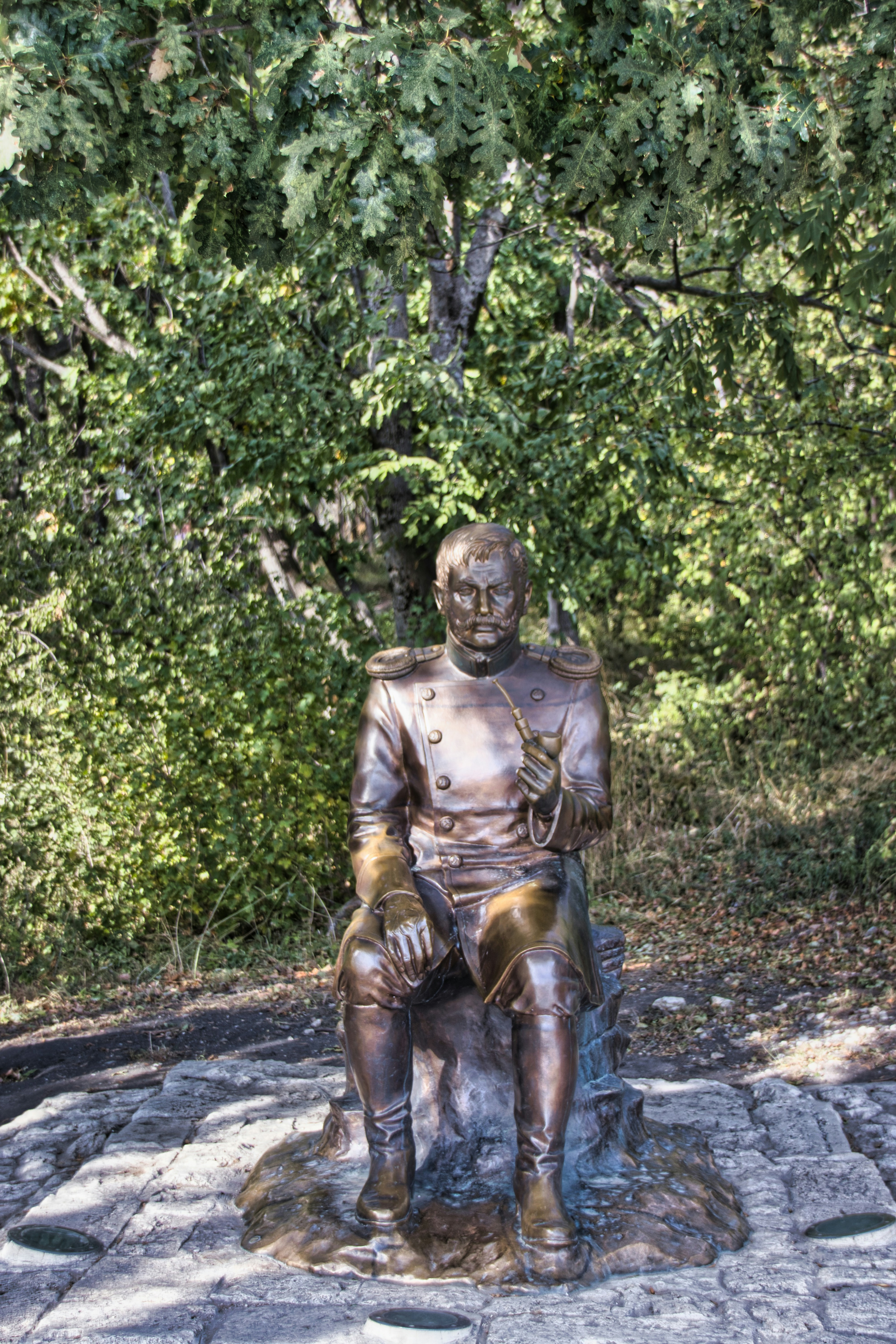 A bronze statue of a man sitting on a rock