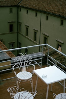 A balcony with a table and chairs on it