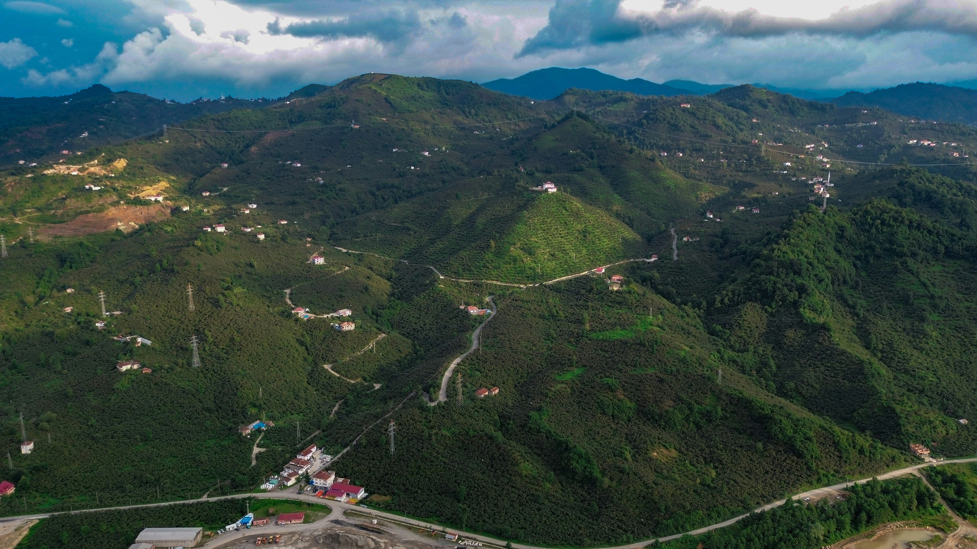 An aerial view of a mountain with a road running through it, 
