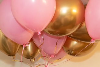 A bunch of pink and gold balloons on a table