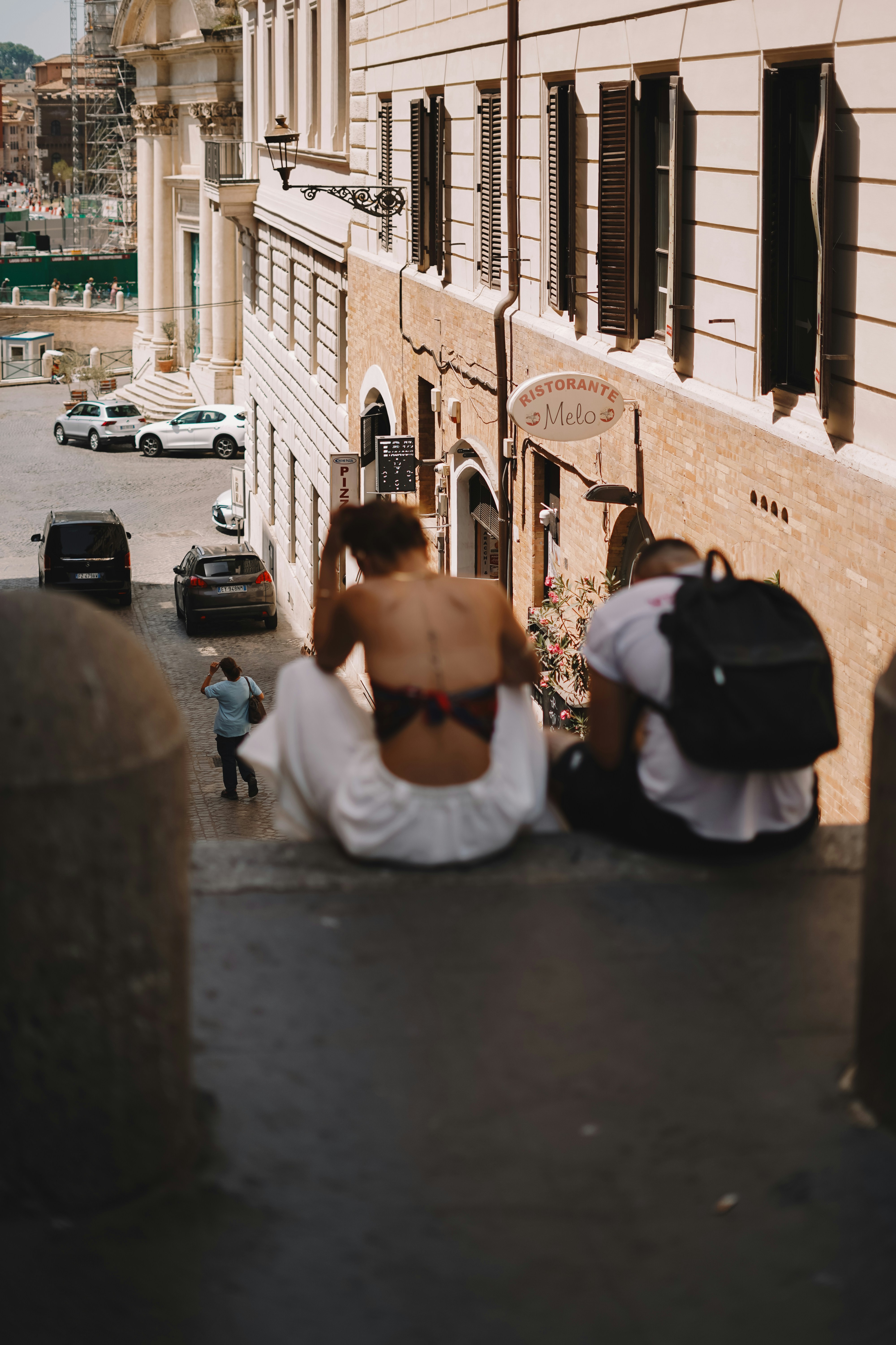A couple of people sitting on the side of a building