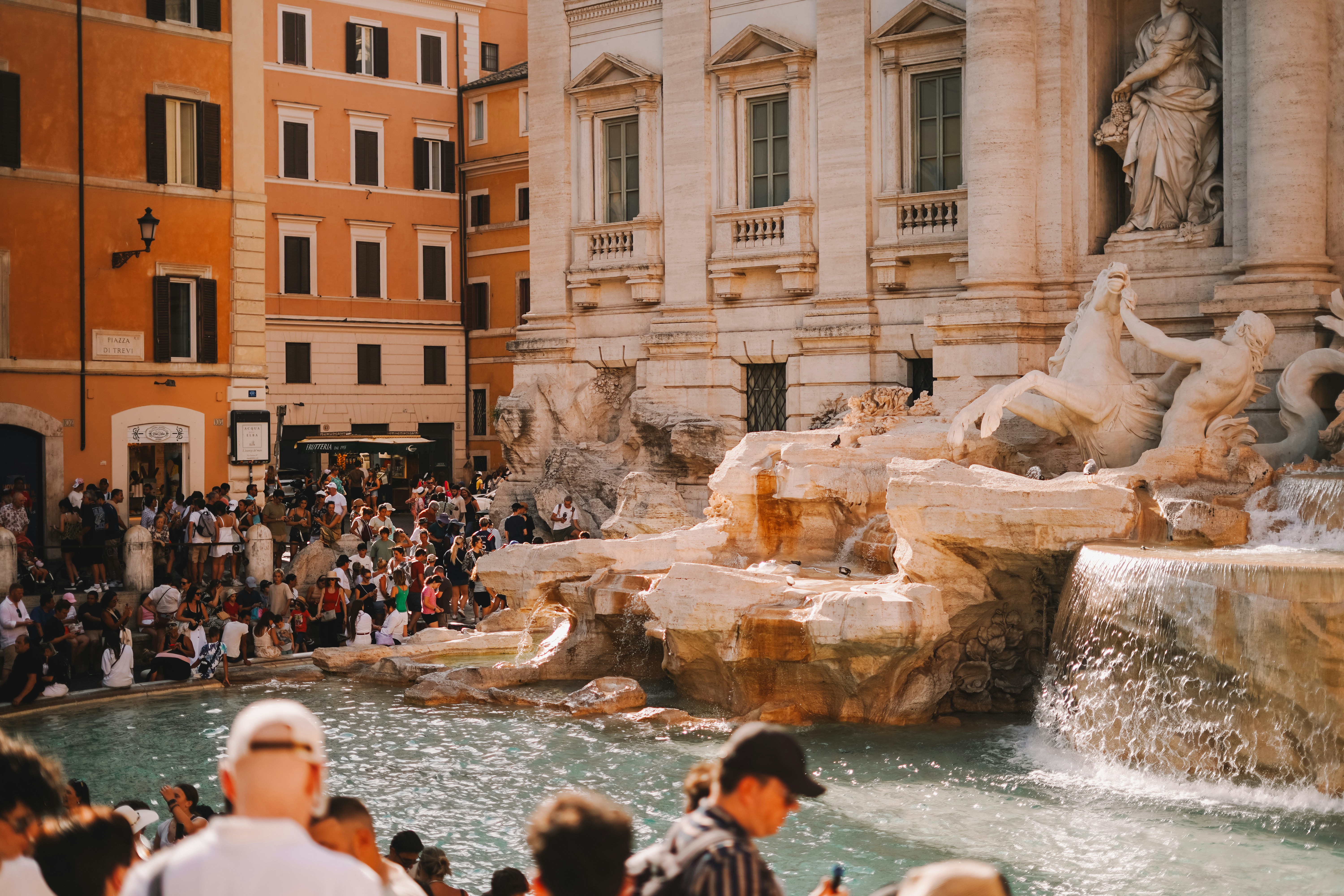 A crowd of people standing around a fountain