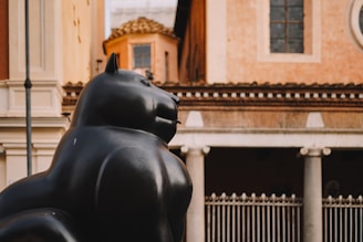 A statue of a cat in front of a building