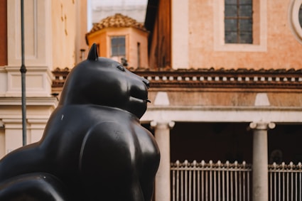 A statue of a cat in front of a building