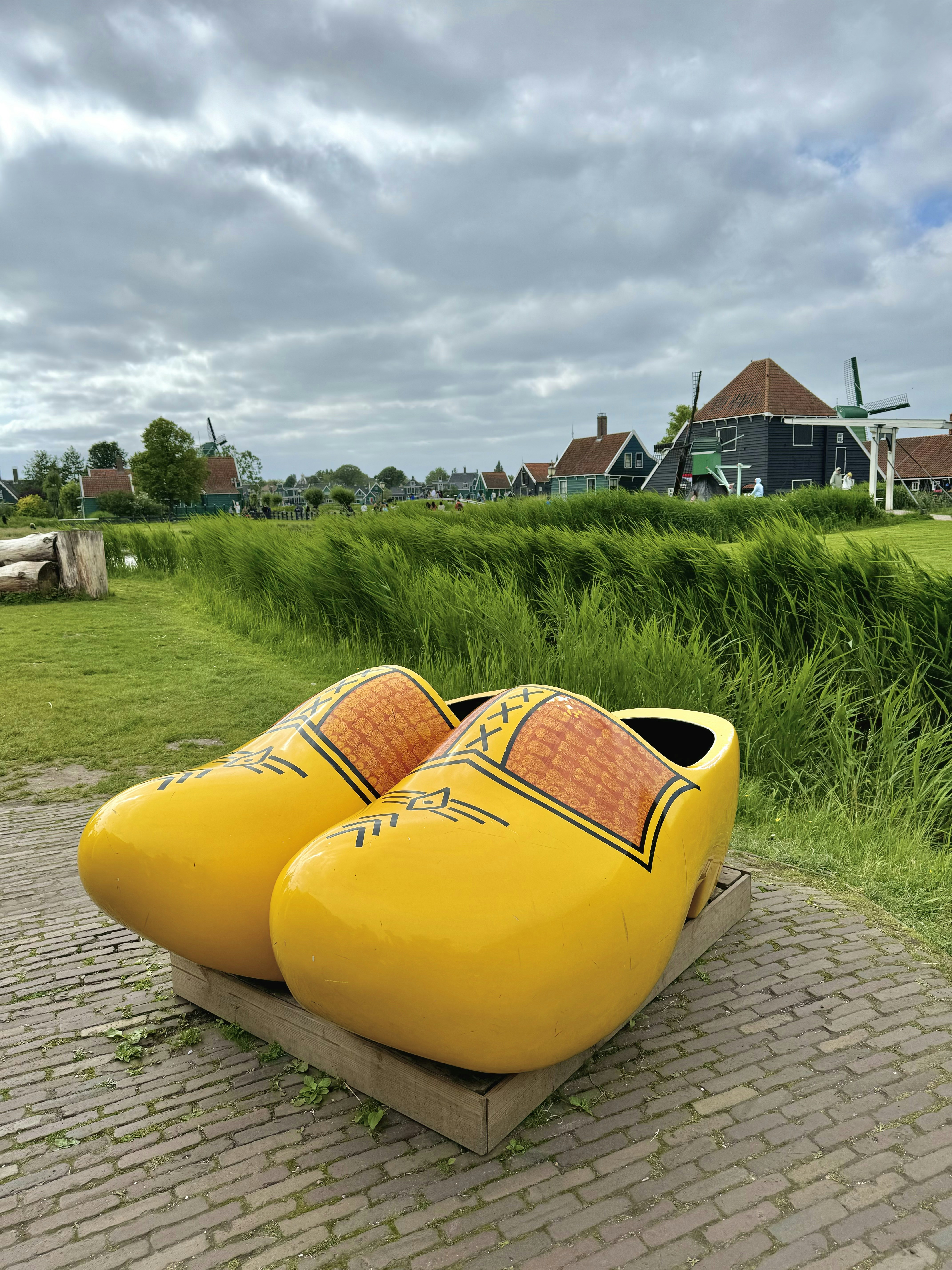 A pair of yellow shoes sitting on top of a brick walkway