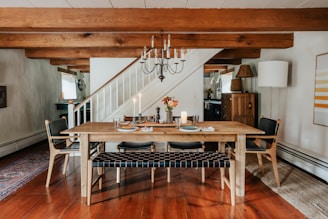 A dining room with a wooden table and a chandelier