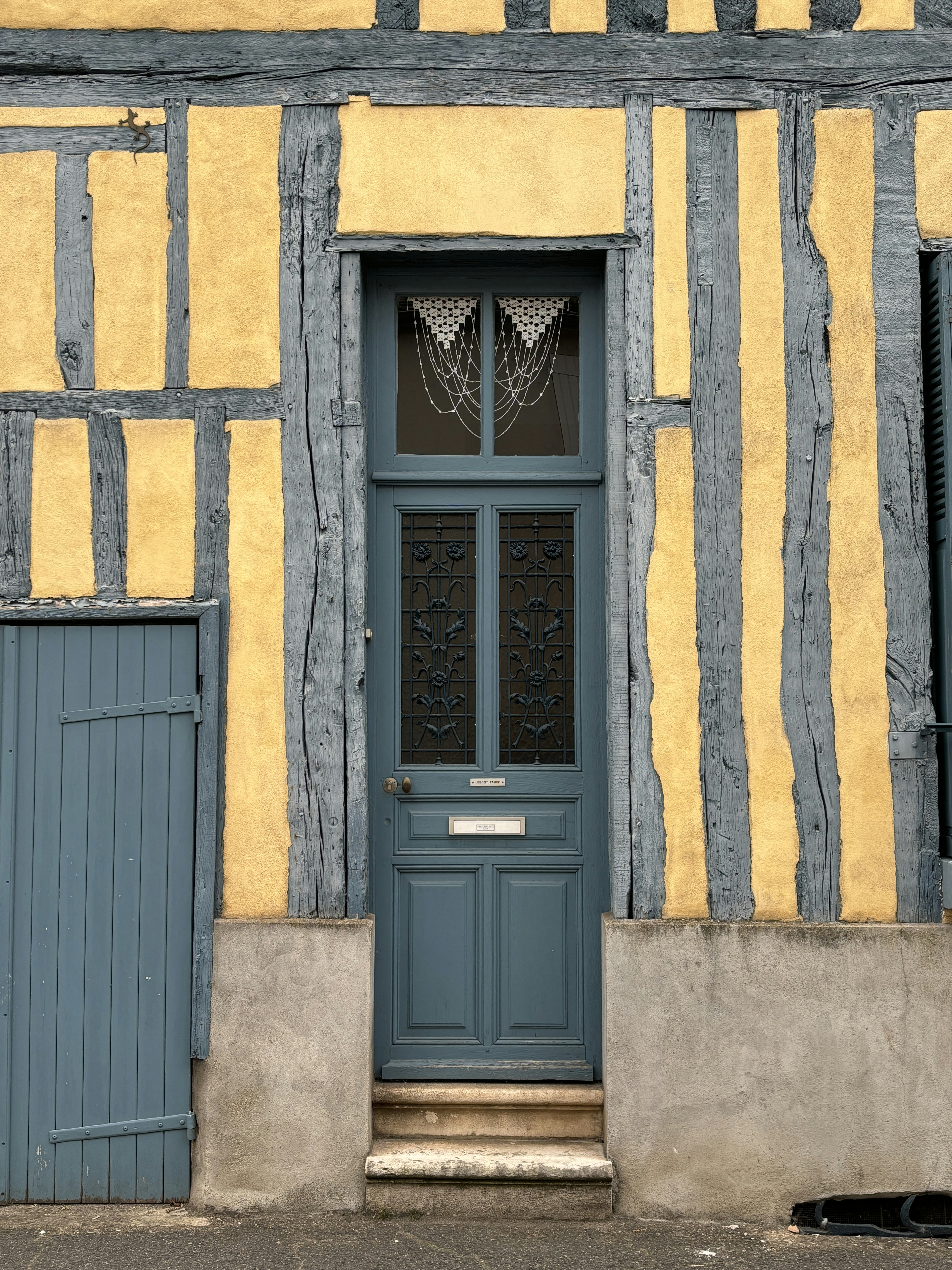 A yellow and blue building with a blue door