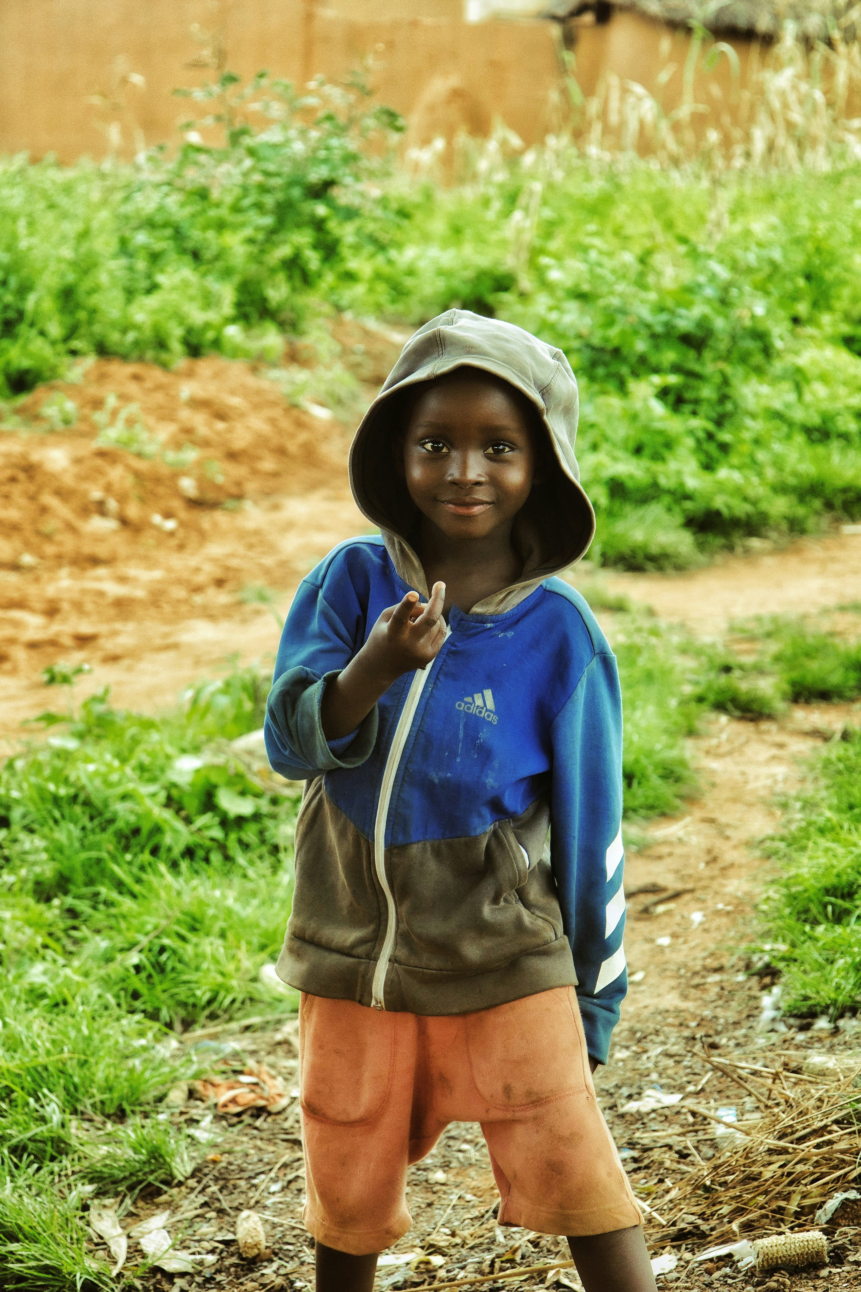 Child wearing a blue denim jacket, bright natural daylight, outdoor setting