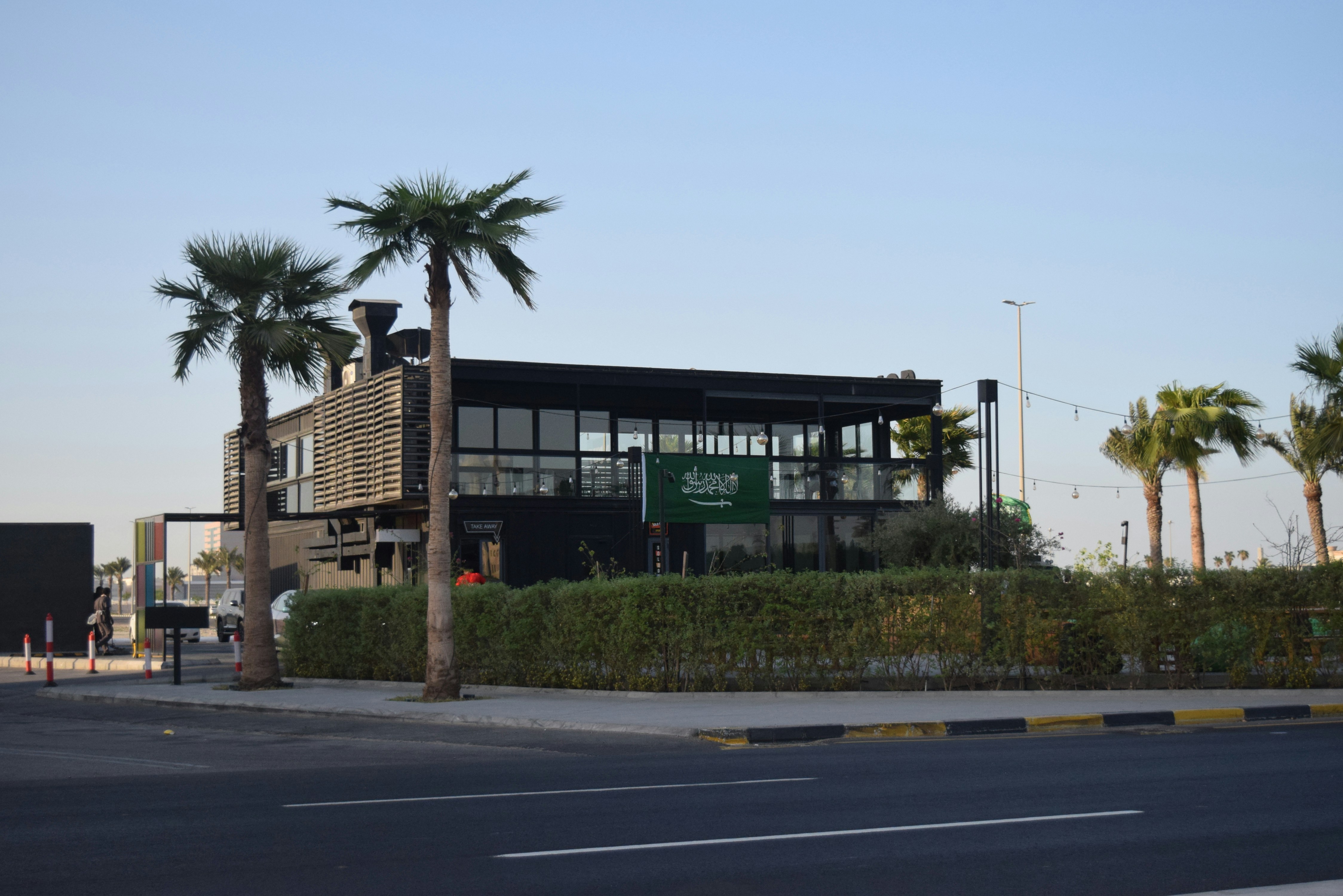 Un bâtiment avec des palmiers devant lui