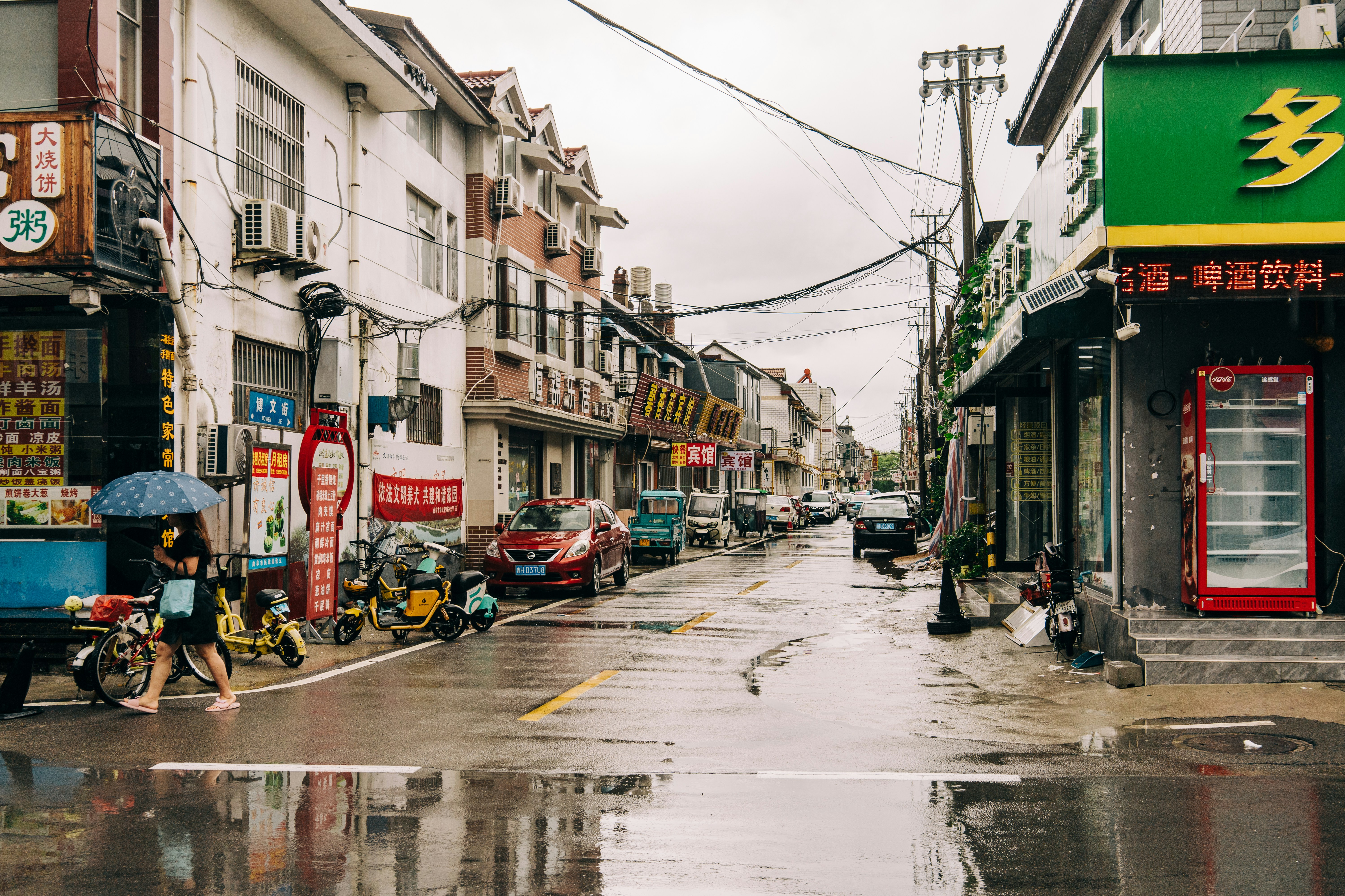 A city street with buildings and cars on a rainy day