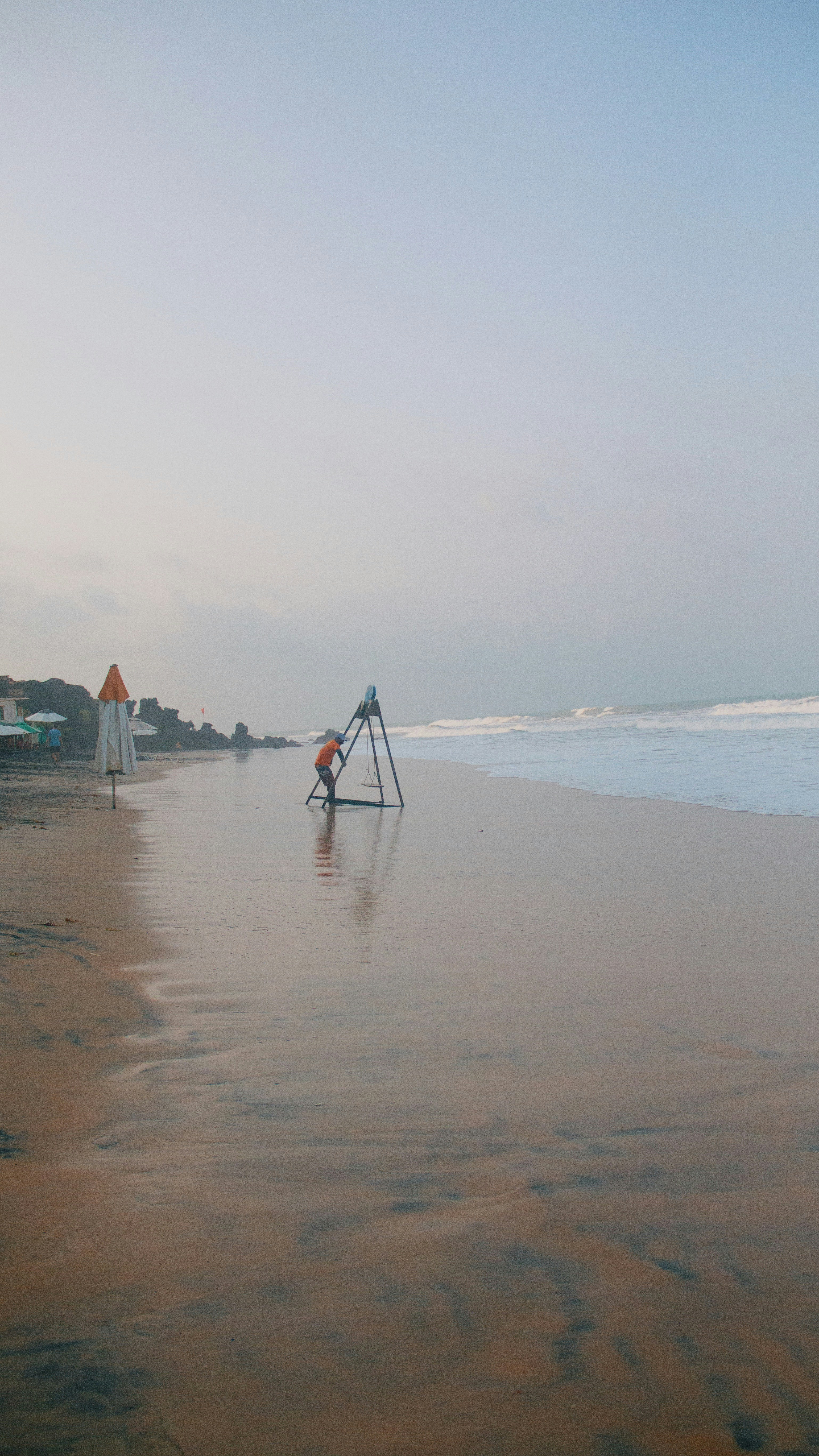 A view of a beach with a lifeguard tower in the foreground