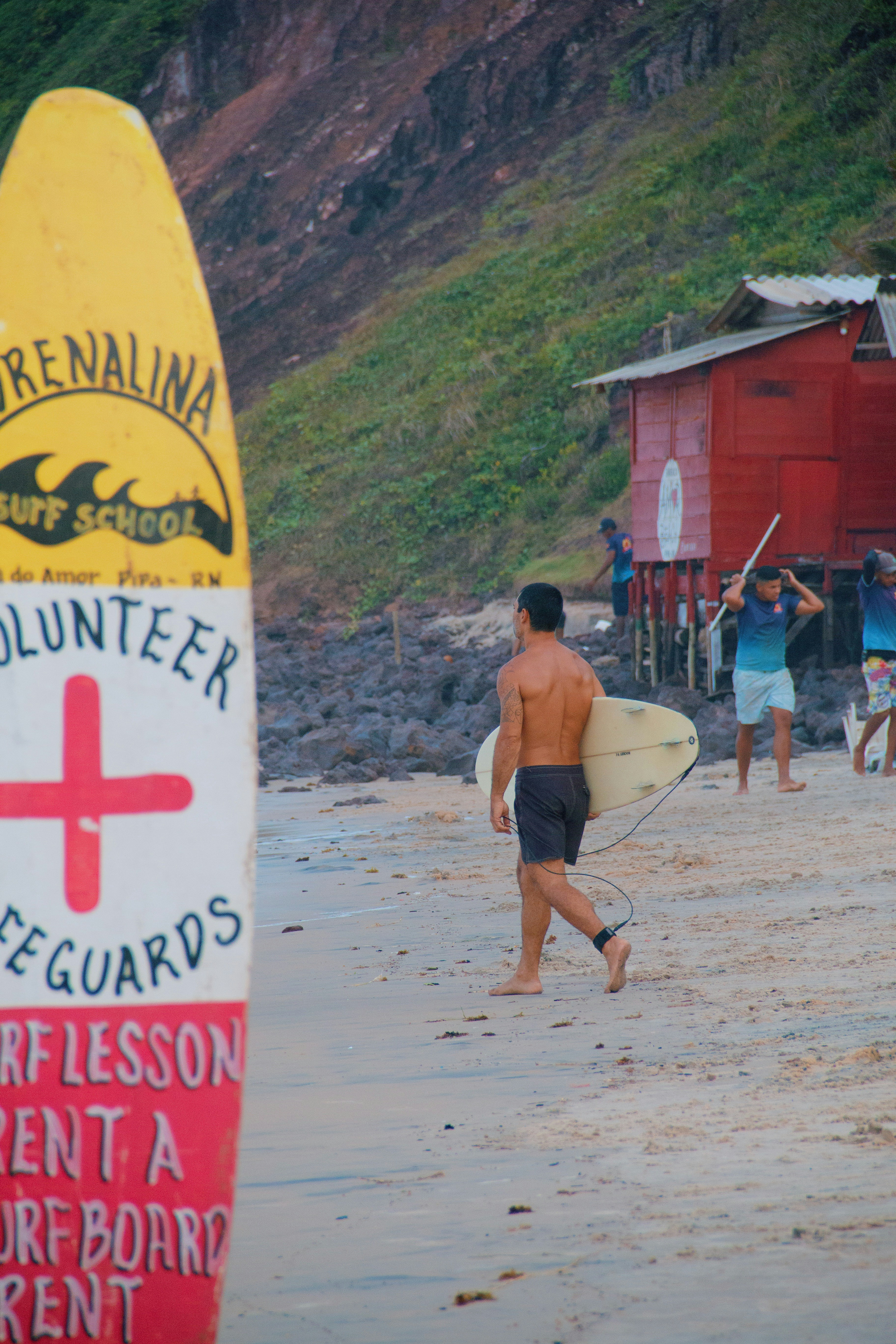 A man walking on a beach with a surfboard