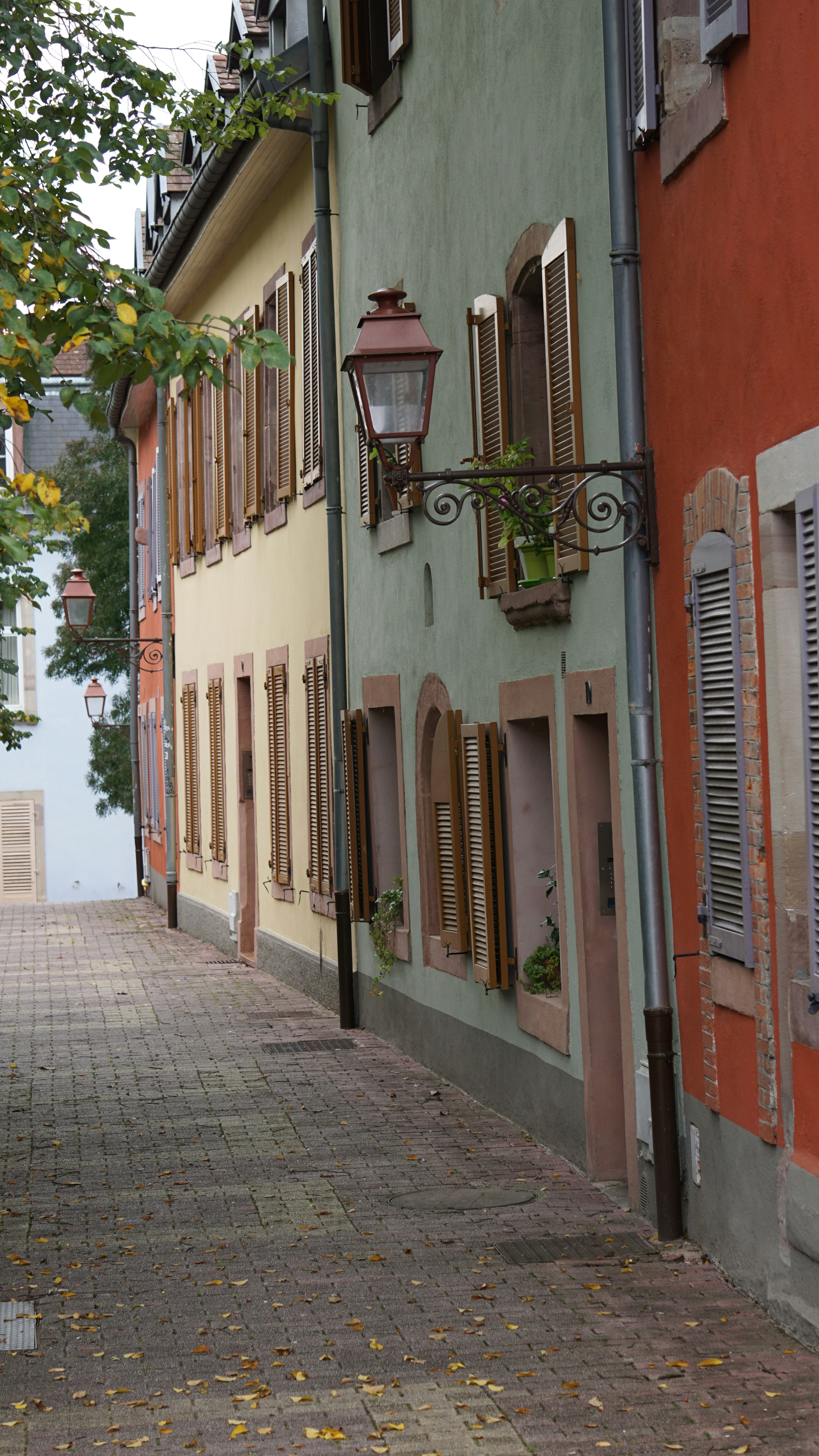 Une bouche d’incendie rouge posée sur le bord d’une route en briques