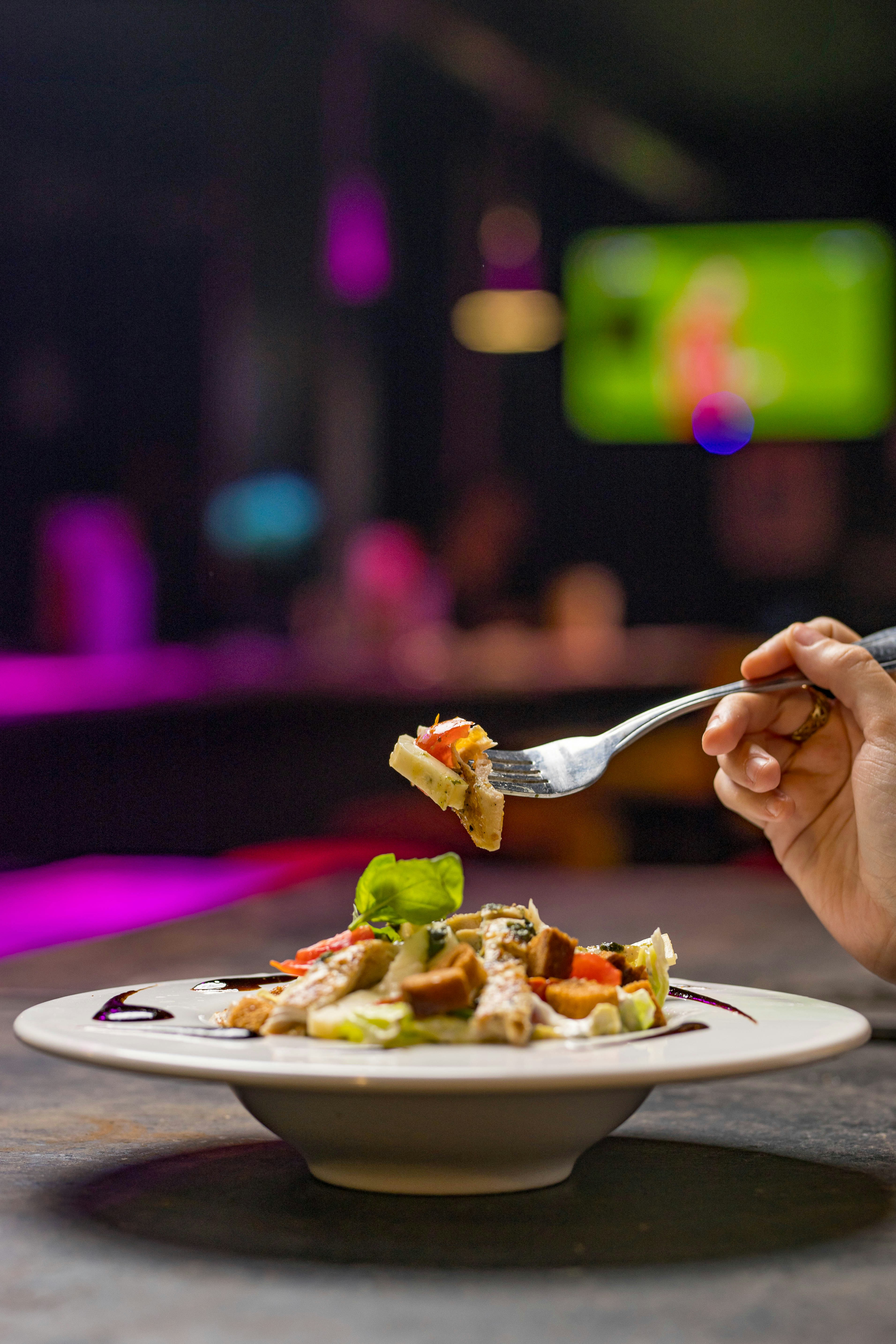 A person eating a plate of food with a fork