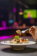 A person eating a plate of food with a fork