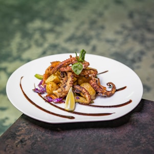 A white plate topped with food next to a body of water