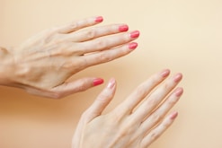 A woman's hands with red nail polish on them