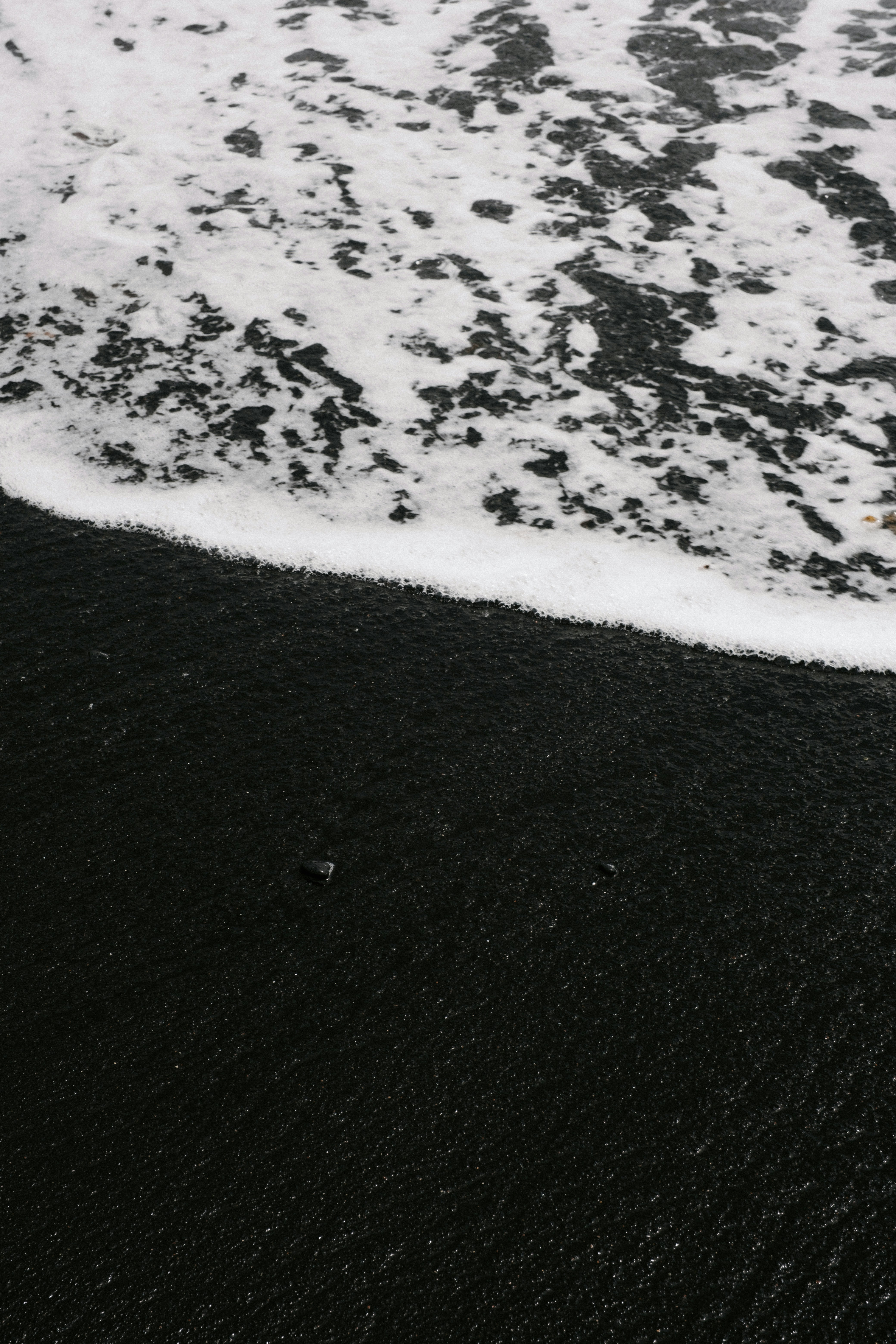 A wave rolling onto a black volcanic sand beach in Lanzarote