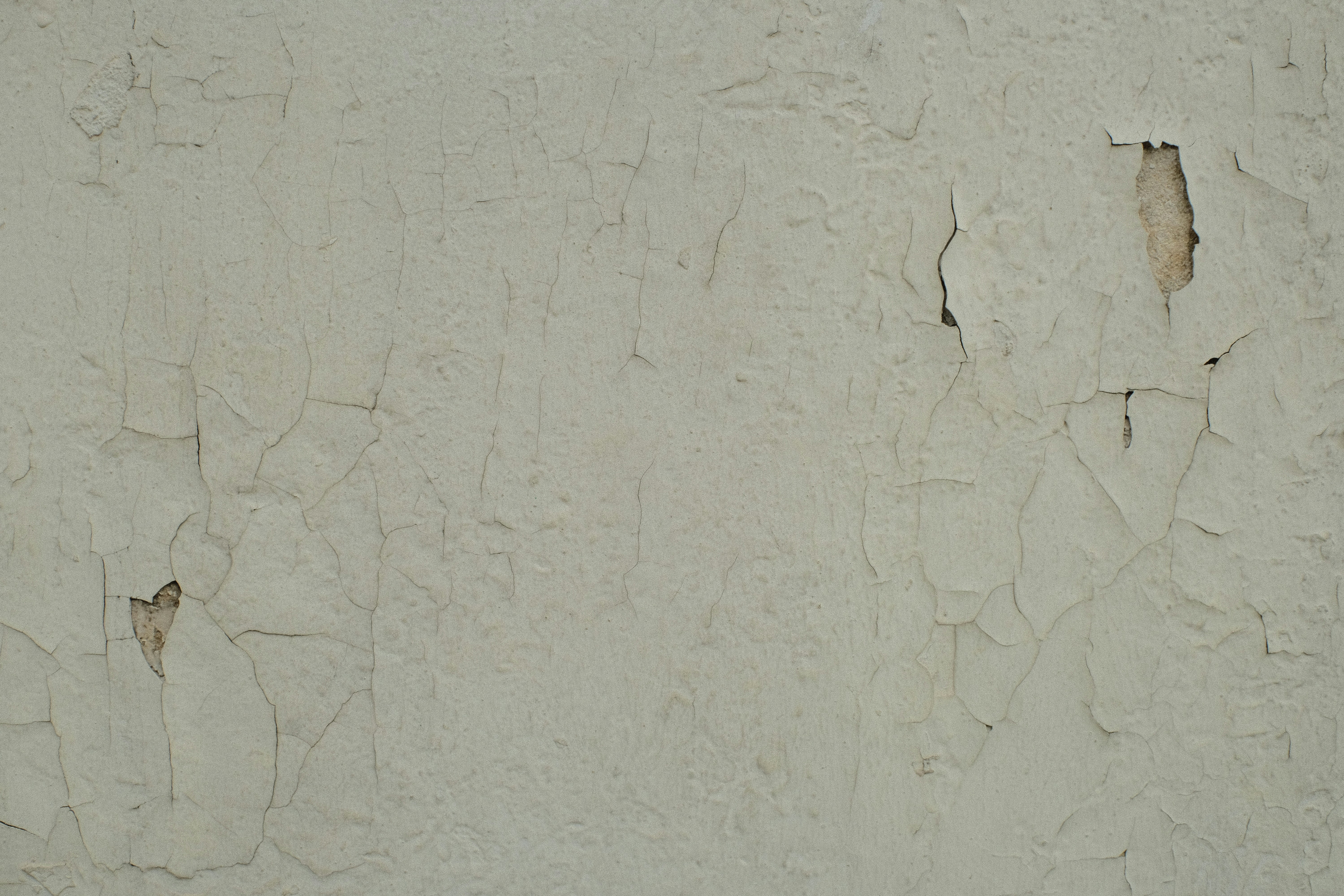 Beyaz bir duvardaki kalem ve pastel boya izlerini sünger yardımıyla temizleyen bir el.