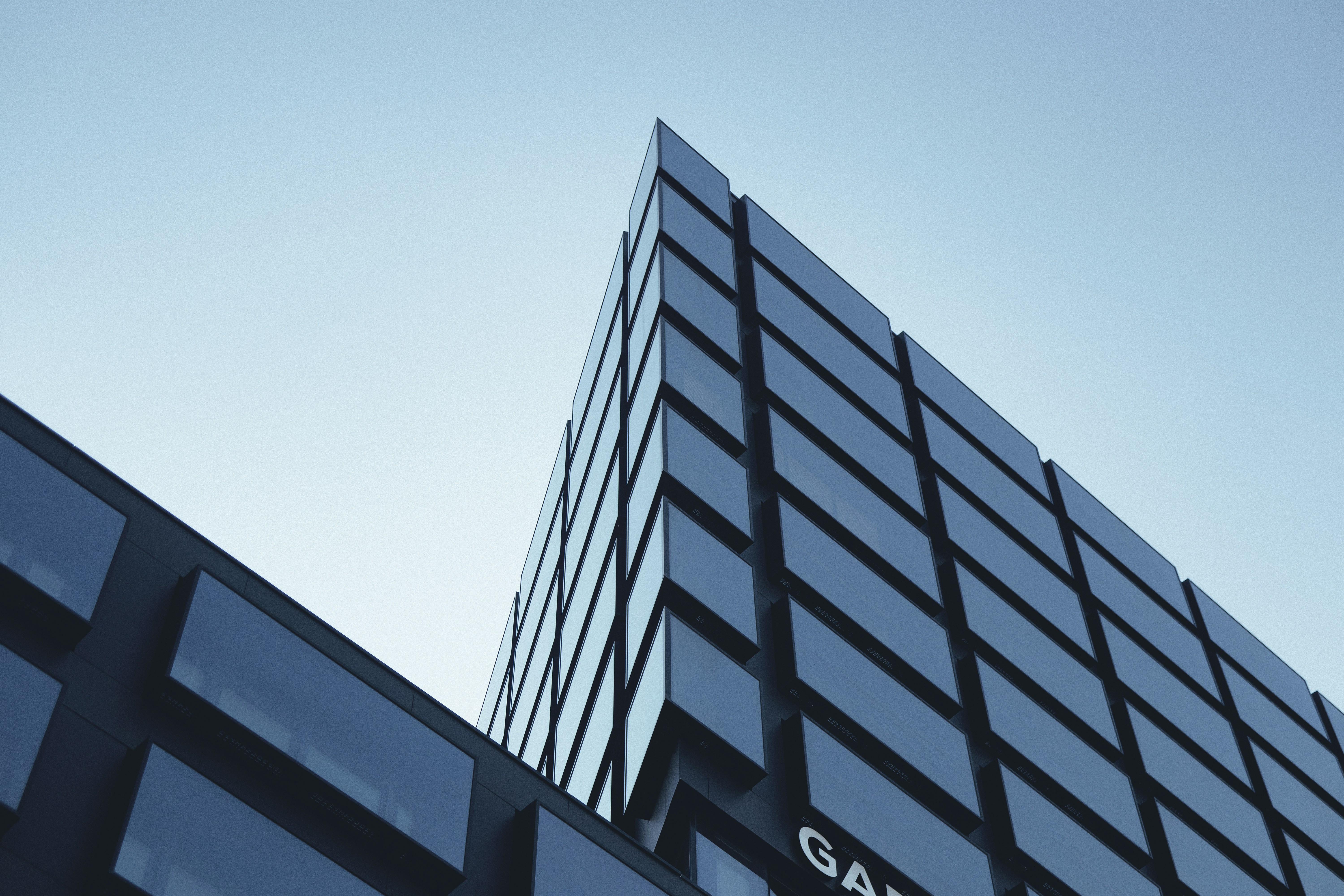 A tall black building with a sky in the background