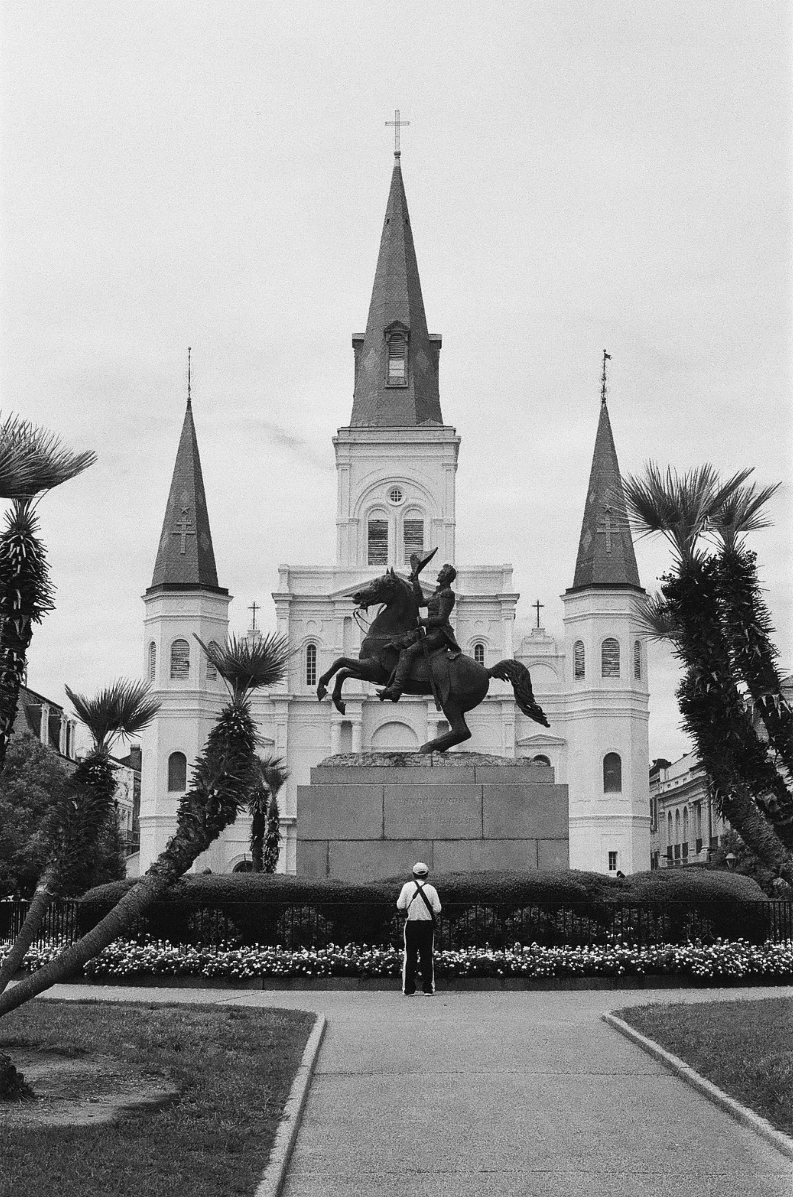 Man looking at statue in front of church. Shot in Canon ae-1 on Ilford 400 film pushed +1