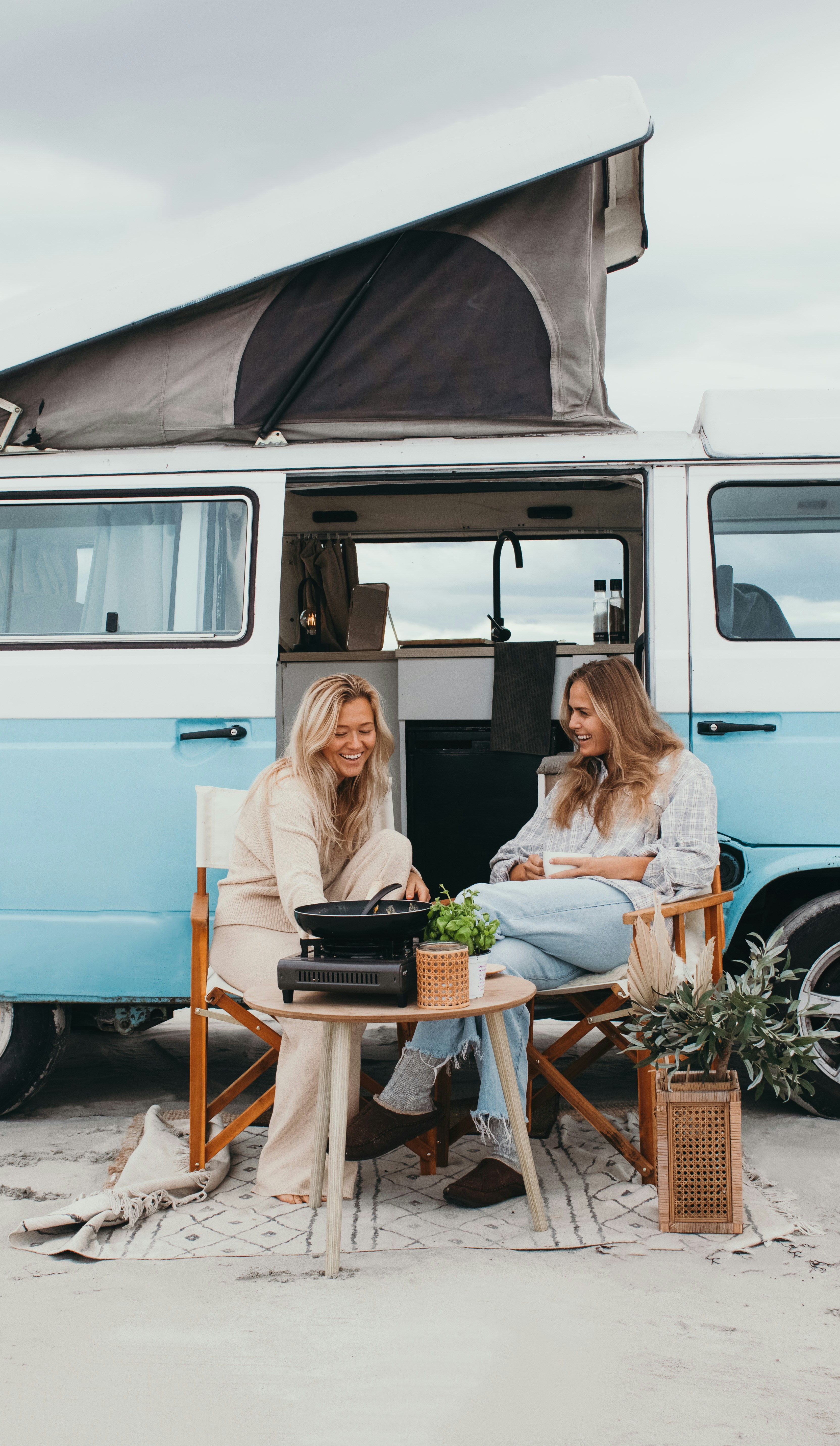 Two women sitting at a table in front of a van