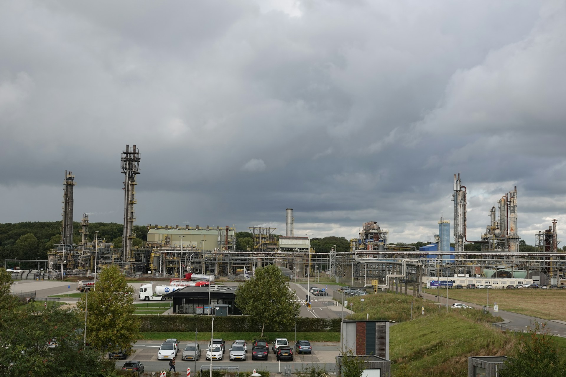 A factory with a lot of cars parked in front of it