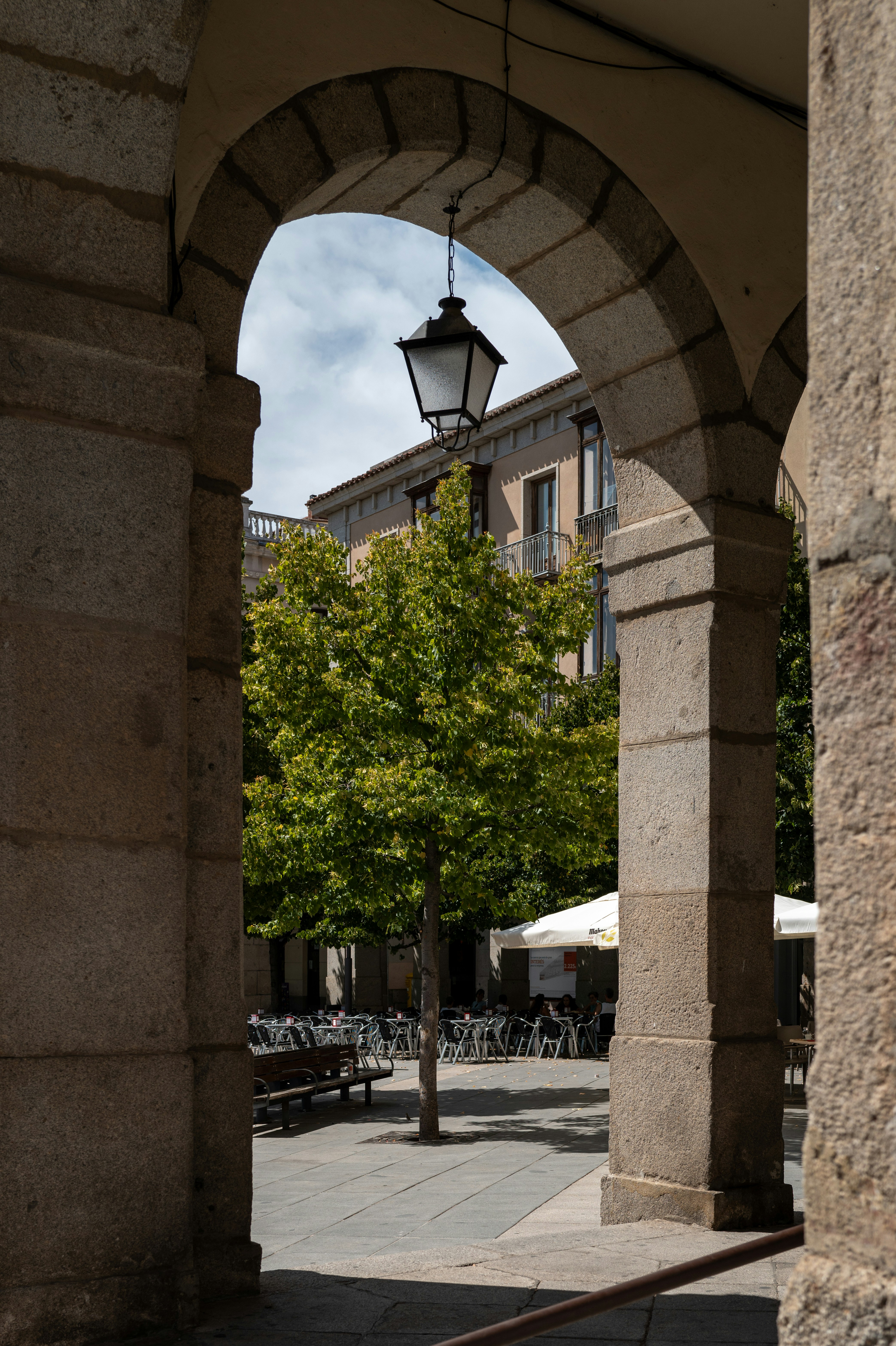 A stone archway with a lamp post in the middle of it