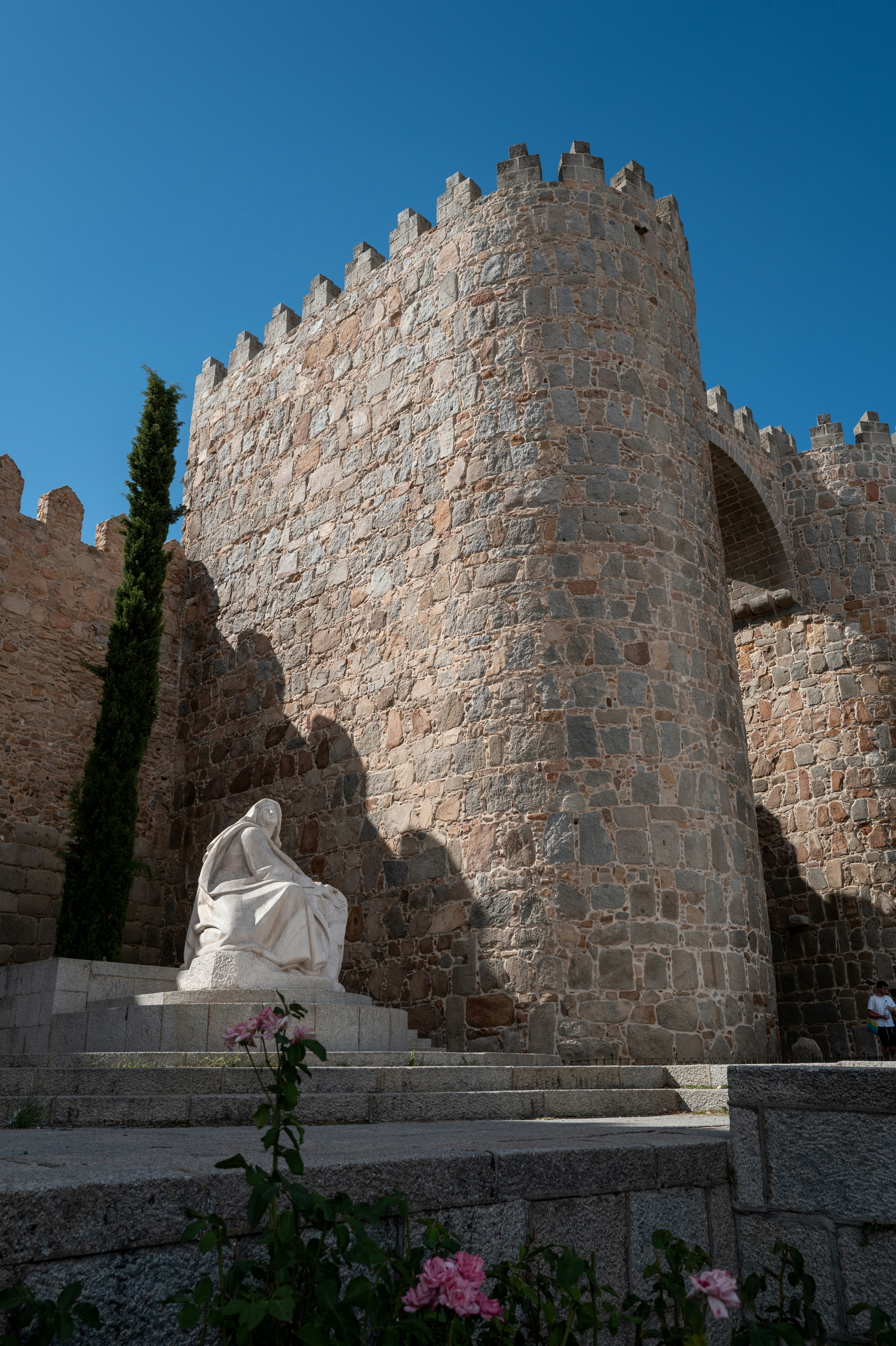 A stone castle with a statue in front of it