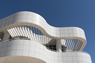 A tall white building with a balcony on top of it