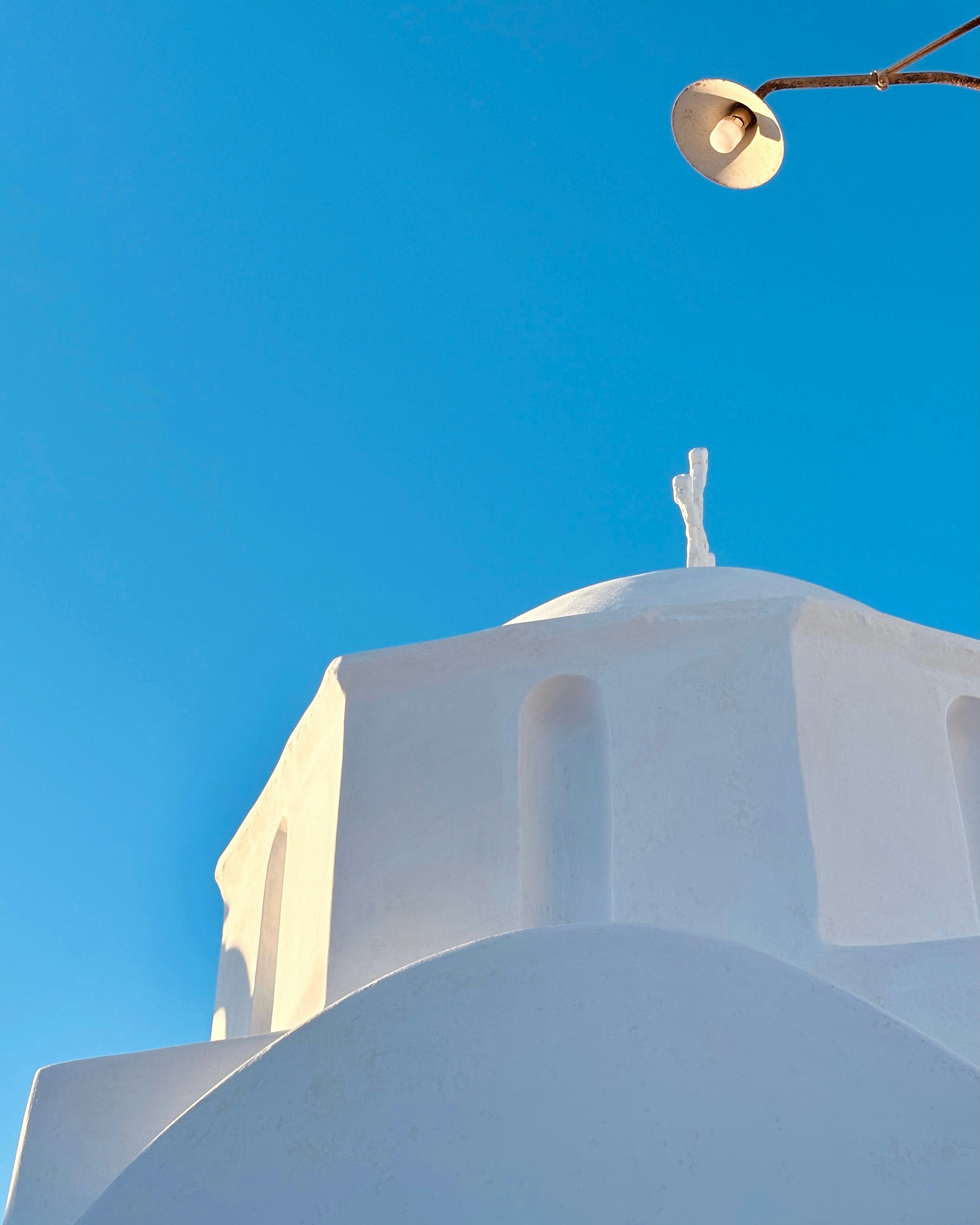 A white building with a cross on top of it