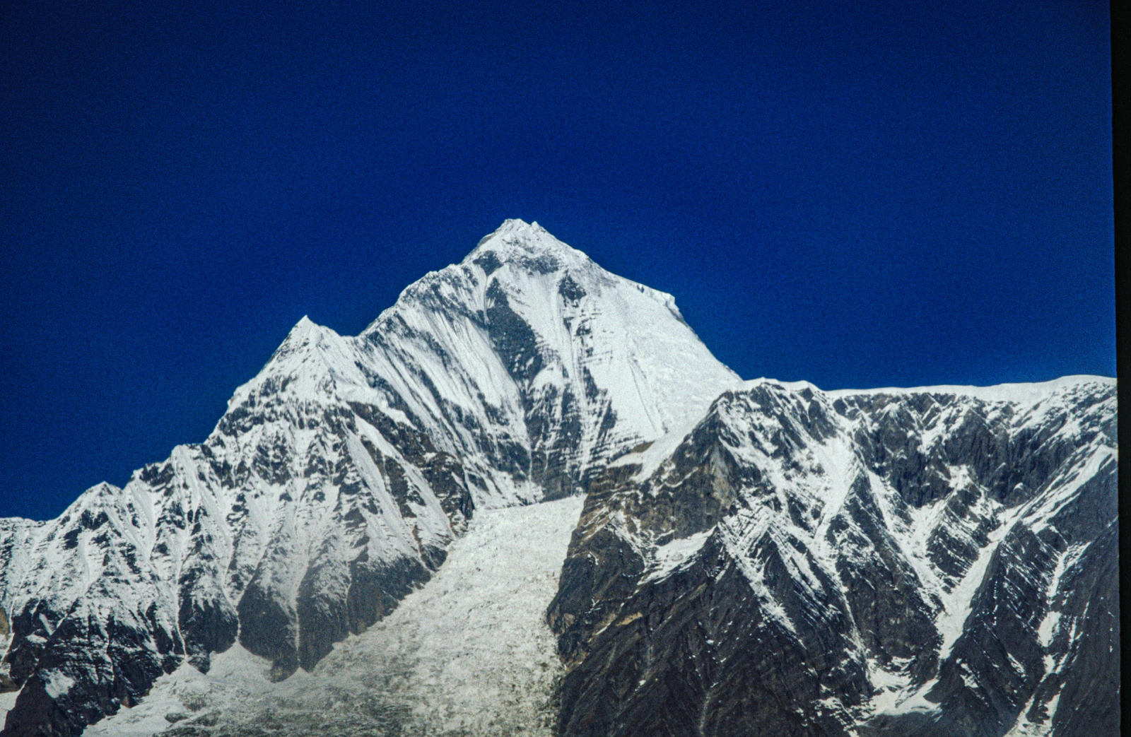 Sharp snow-capped Himalayan peak under deep blue sky in the Annapurna Himal, Nepal