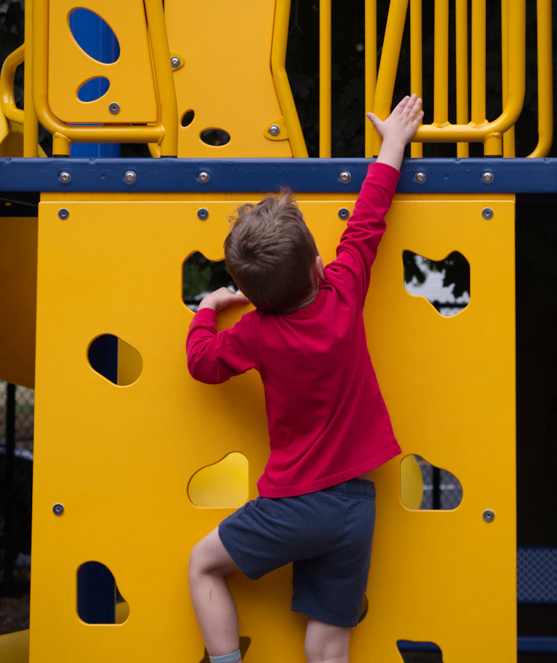 Child playing outdoors on playground equipment