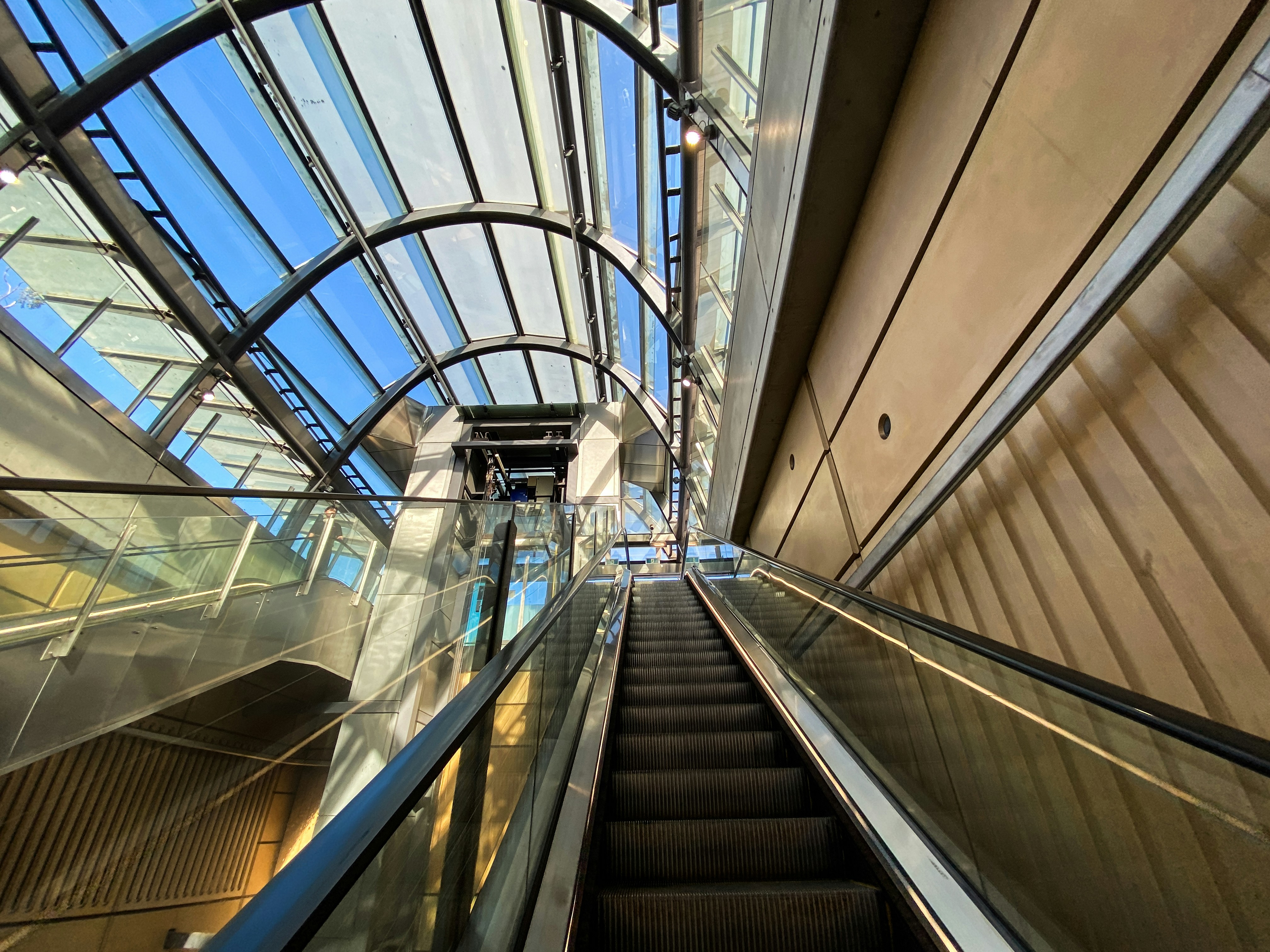 An escalator in a building with a sky background