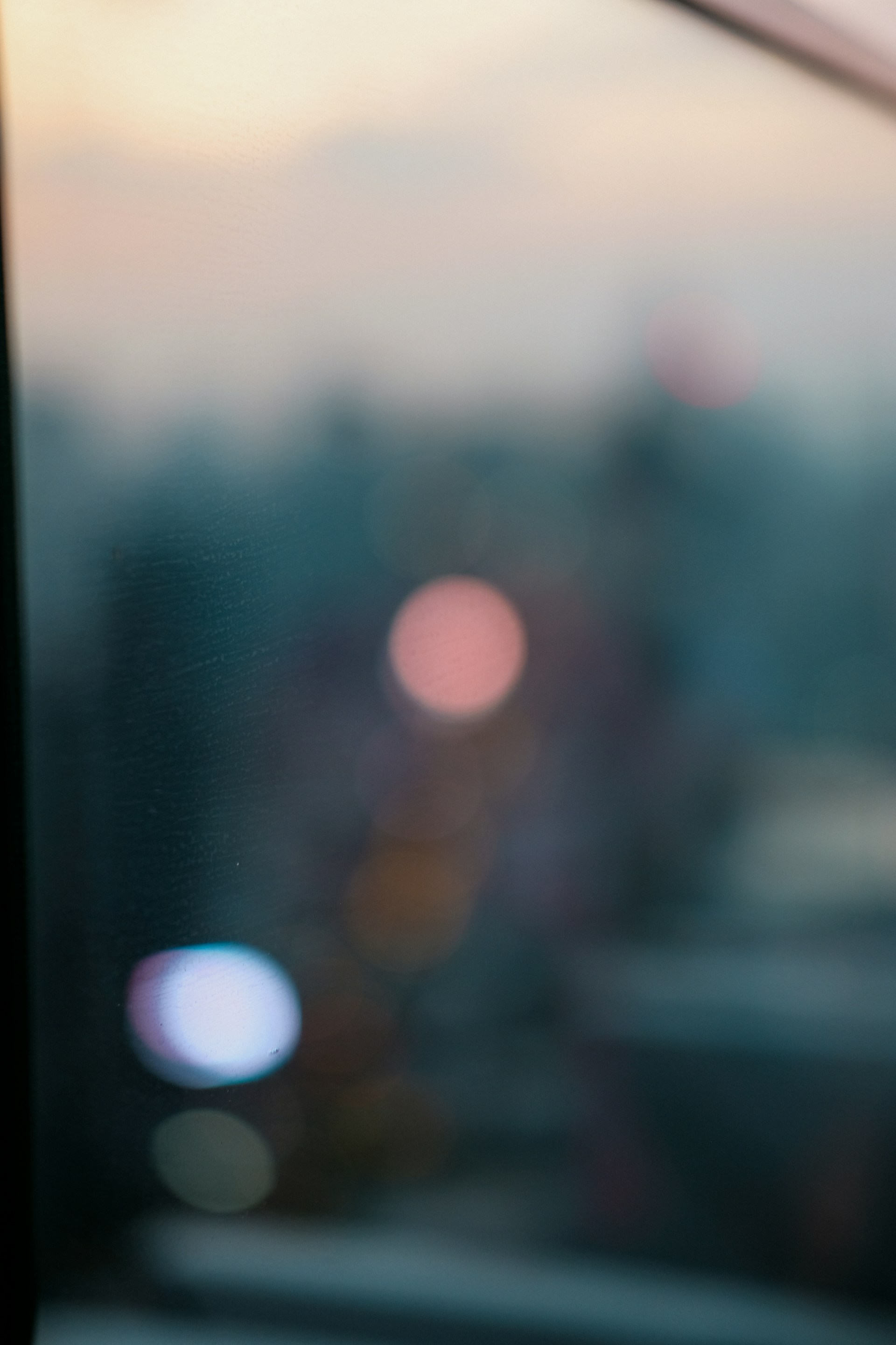 A close up of a window with a blurry city in the background